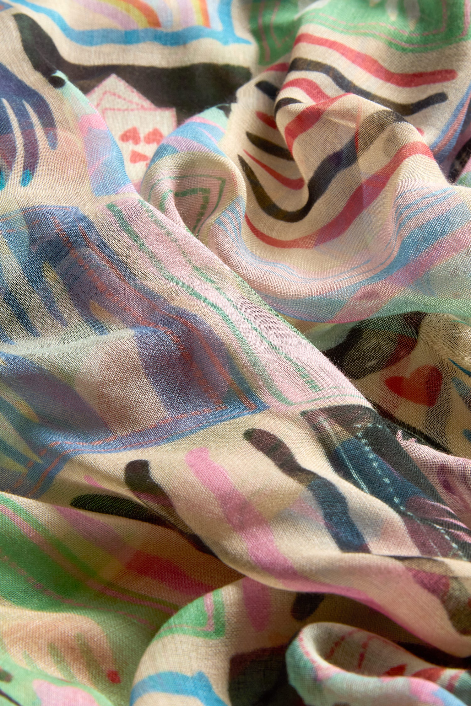 A close-up of the Mystical Collage Scarf showcases its lightweight fabric and storytelling print—multicolored abstract stripes and shapes—bringing vibrant transformation to any outfit.