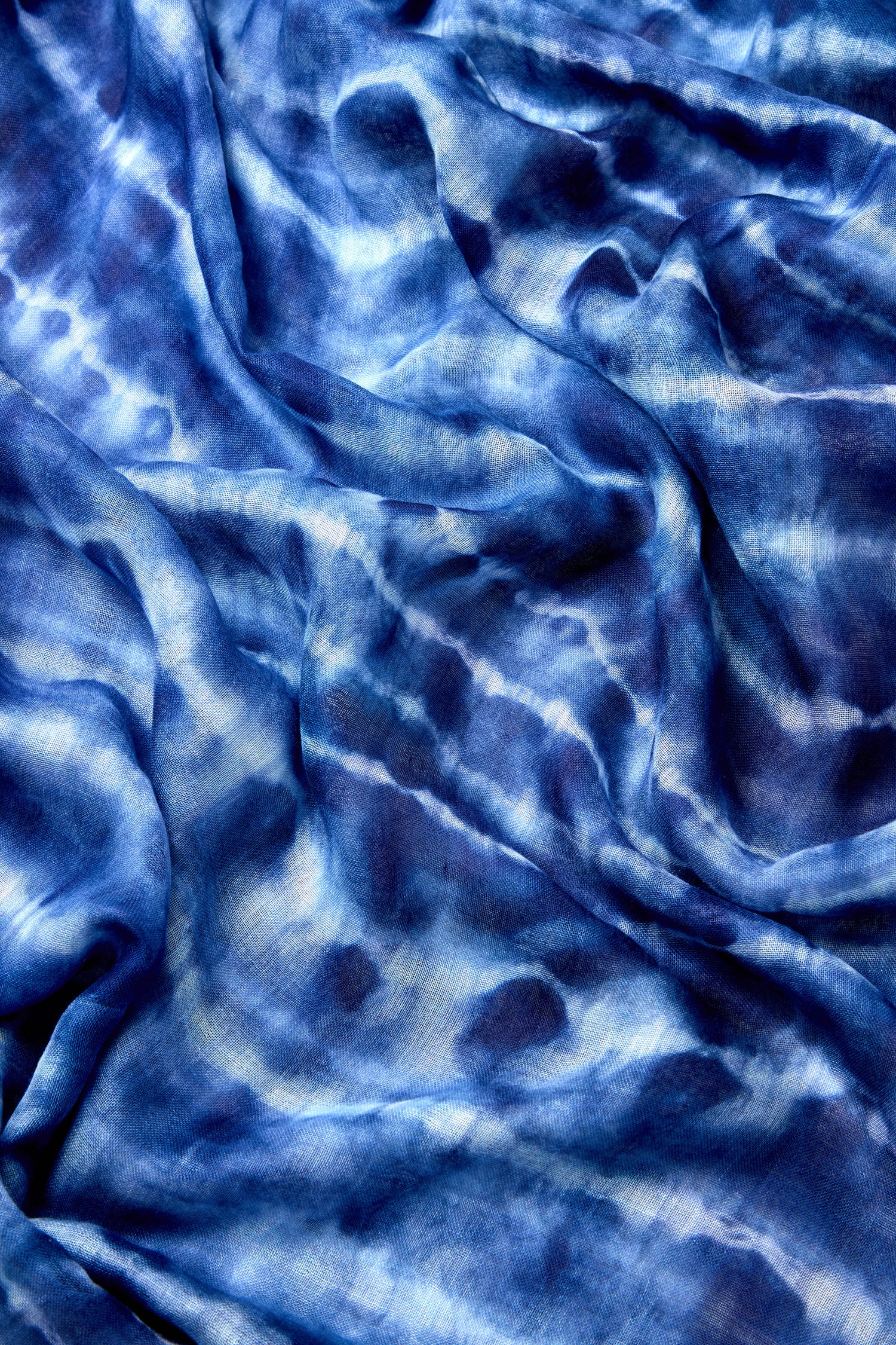 Blue and white tie-dye print with a wrinkled, textured surface and abstract patterns—this Tie Dye Print Scarf is perfect for adding subtle elegance to any look.