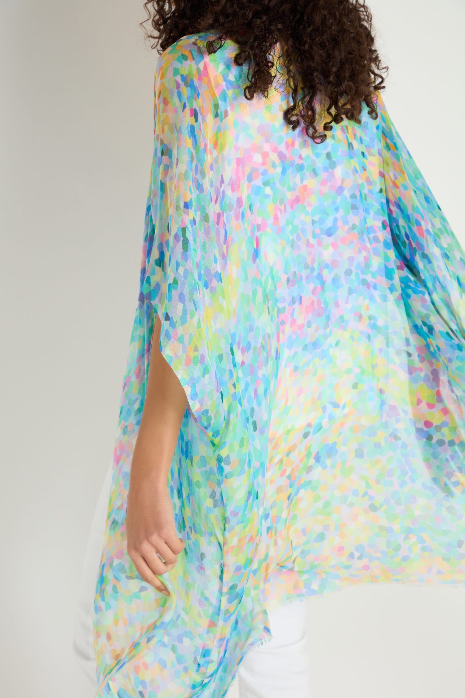 Person wearing the Summer Confetti Burst Kimono—a loose, colorful sheer top with a watercolor pattern—perfect as a lightweight summer layer—shown from the back against a plain background.