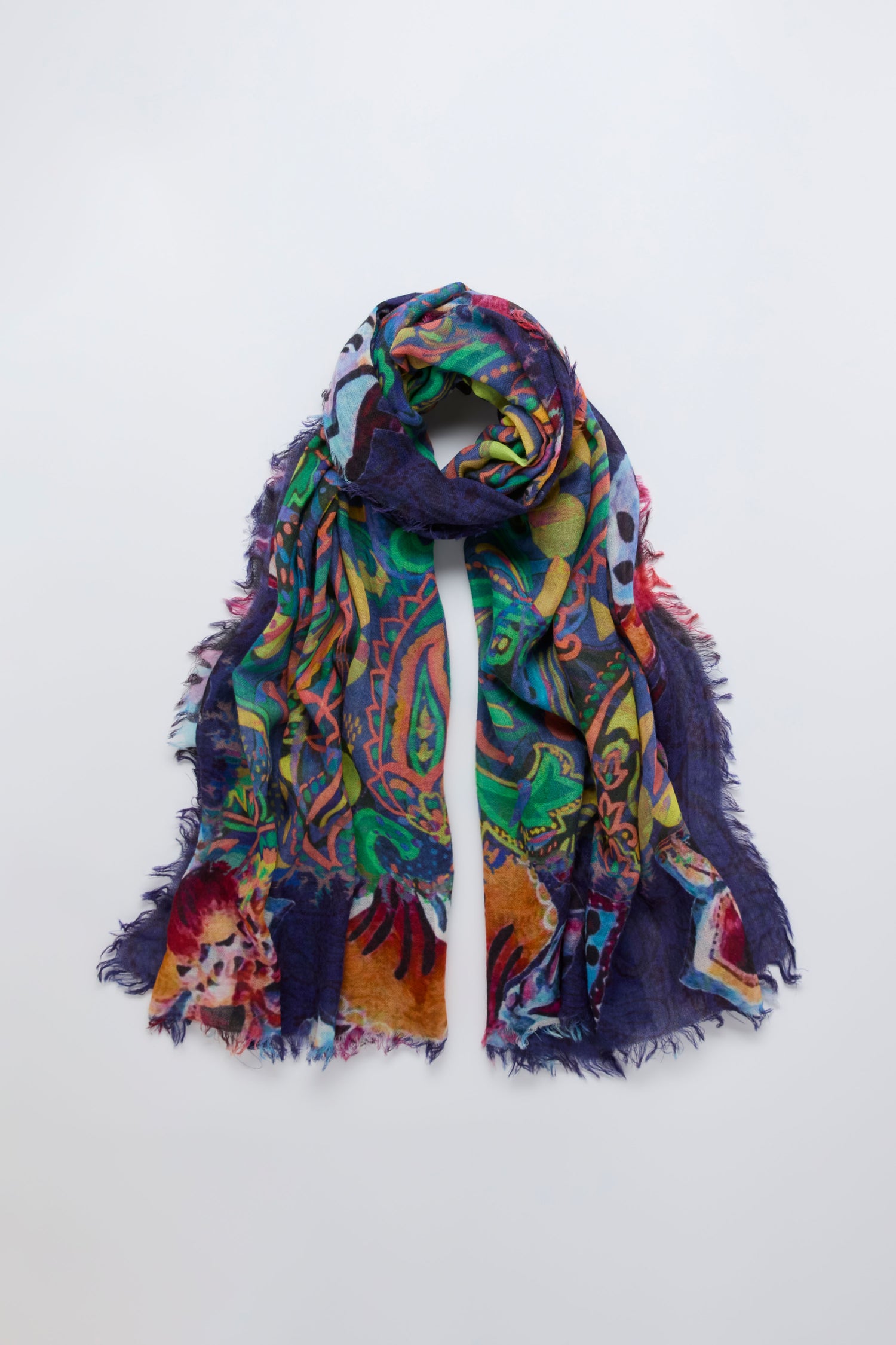 The Painted Paisley Wool Scarf, featuring a vibrant paisley pattern and frayed edges, is displayed on a simple light background.