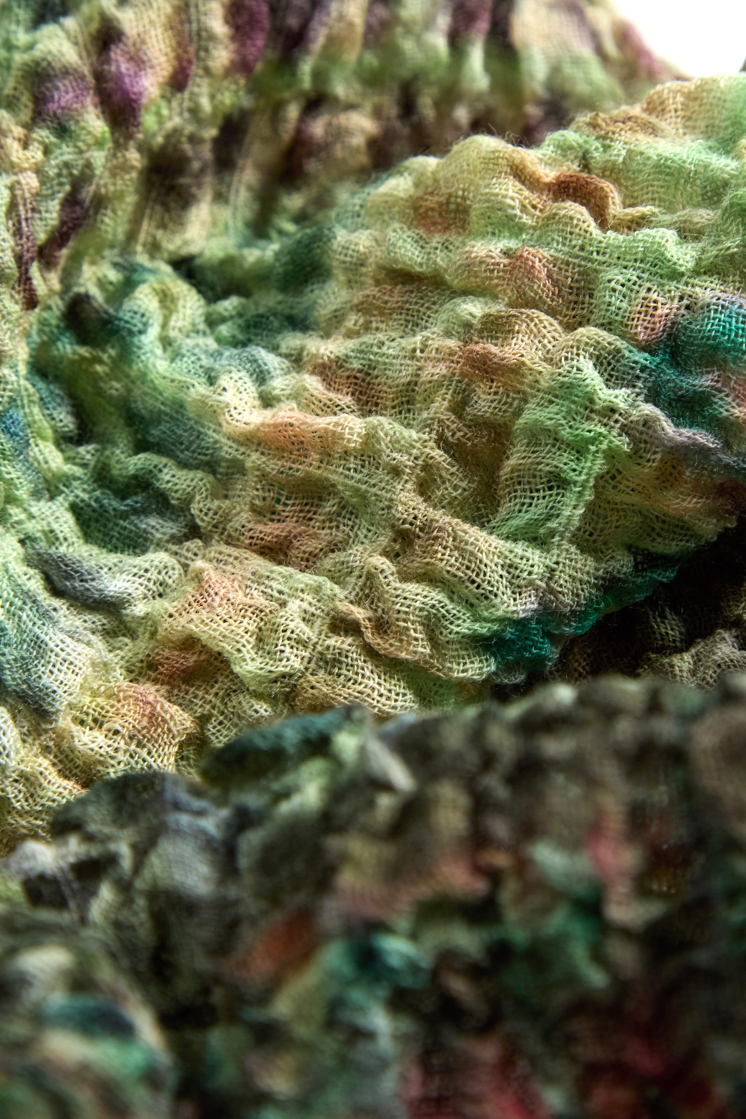 Close-up of the Crushed Digital Print Wool Scarf featuring a multicolored pattern in green, yellow, pink, and black on crushed wool.