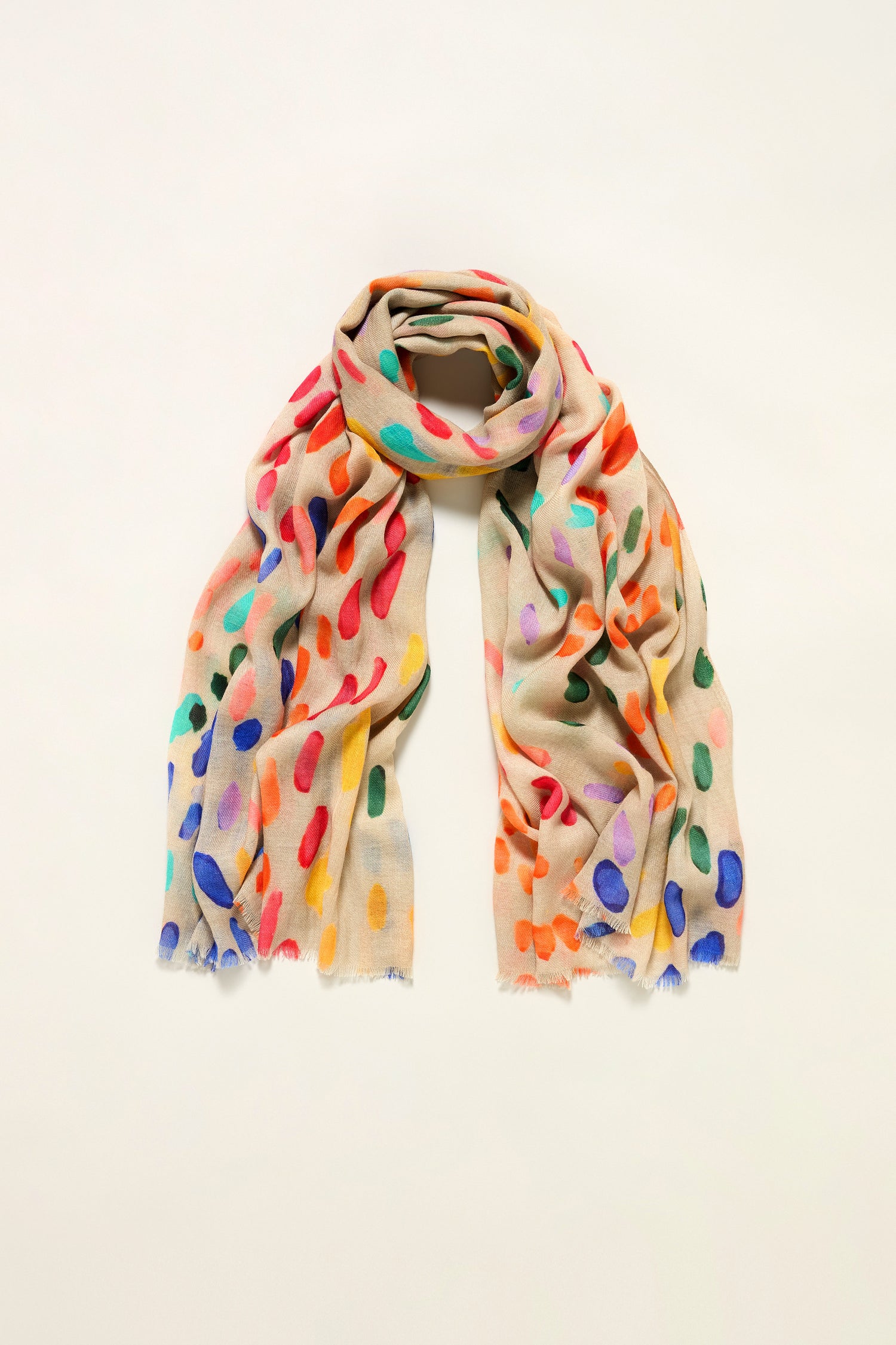 The Artful Dots Wool Silk Scarf features vibrant abstract spots in red, blue, green, orange, and yellow on beige for a colorful look, displayed on a plain light background.