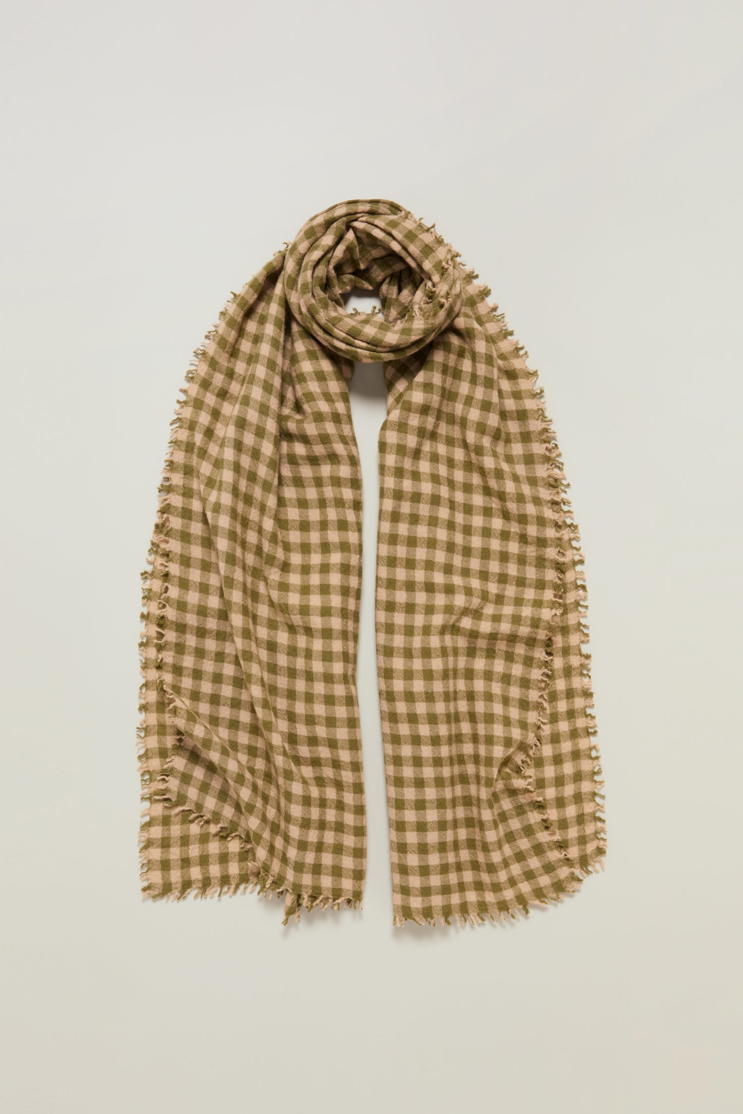 The Boiled Wool Gingham Check Scarf in beige and brown features frayed edges, offering lightweight warmth and timeless style when laid flat against a light background.