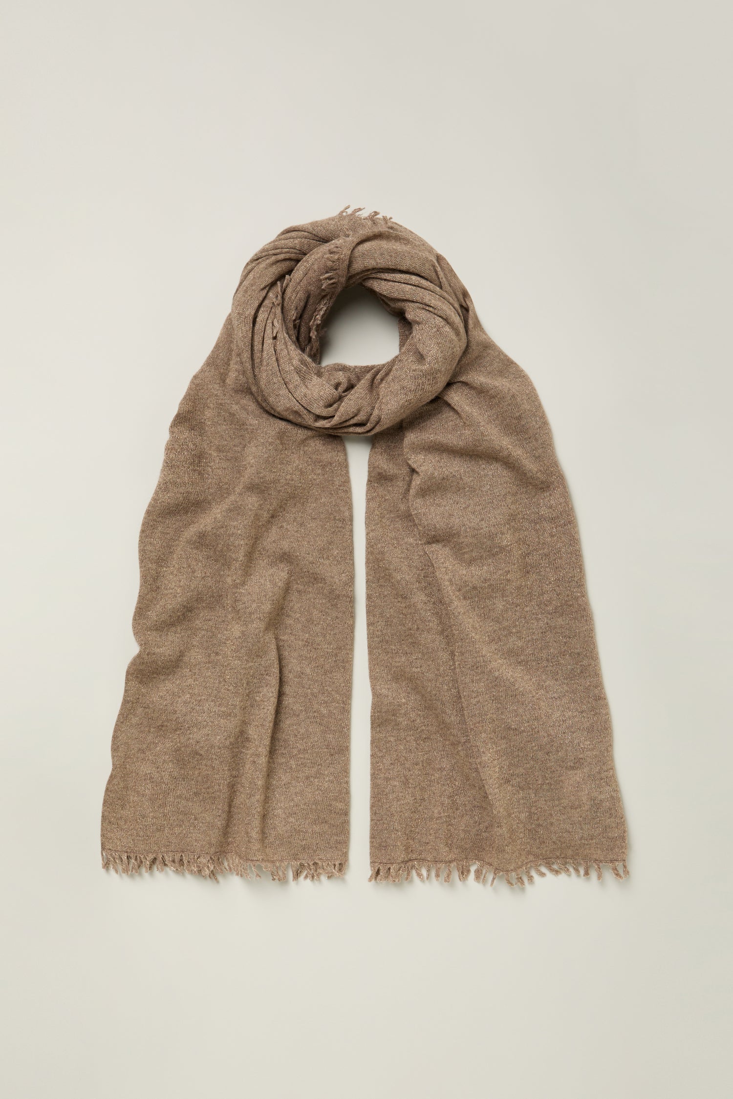The Cashmere Sparkle Scarf, in light brown pure cashmere with frayed edges, is displayed flat on a simple neutral background.