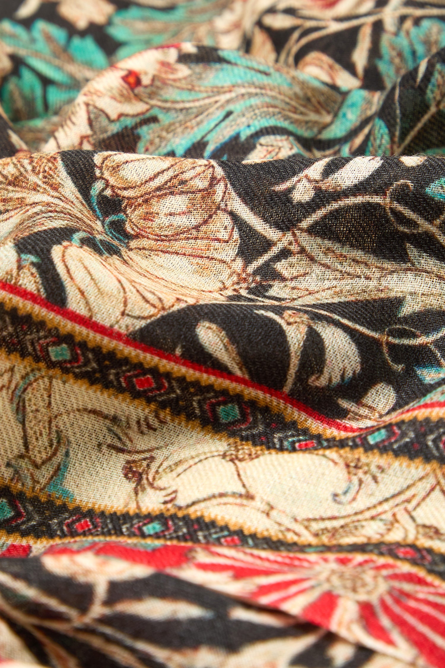 Close-up of the Ornamental Floral Wool Mix Scarf featuring intricate floral and geometric patterns in beige, black, red, and teal tones.