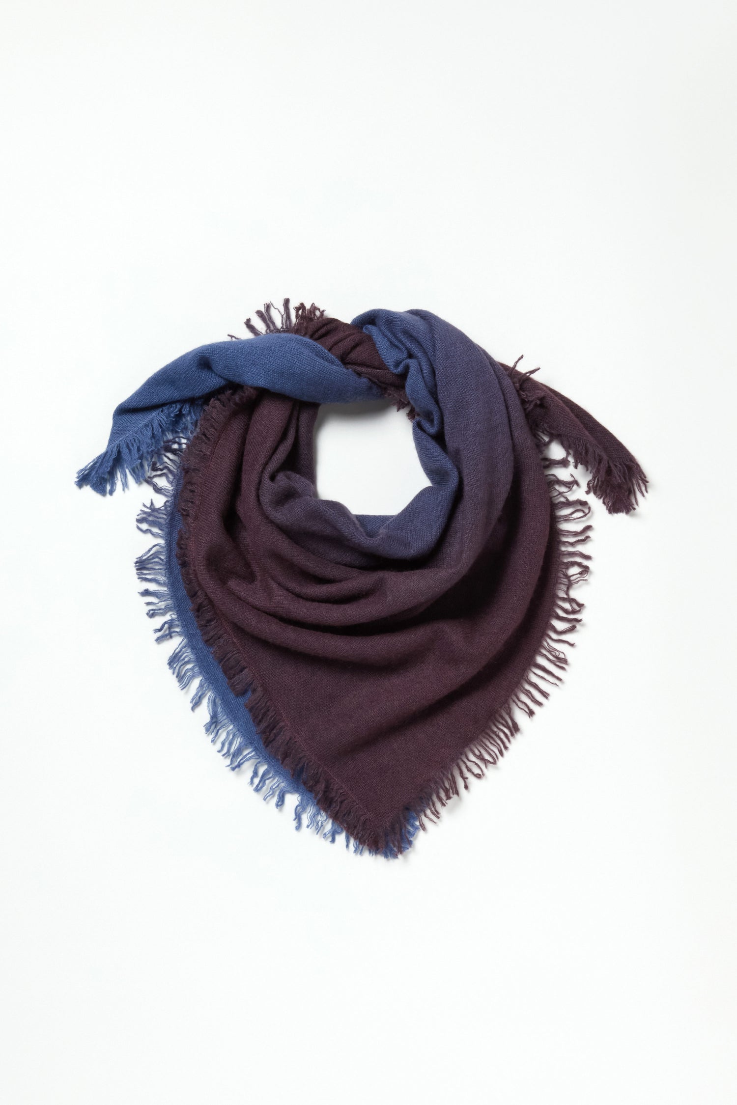 The Ombre Cashmere Square Scarf, featuring blue and dark purple sections with fringe detailing, is displayed flat on a white background.
