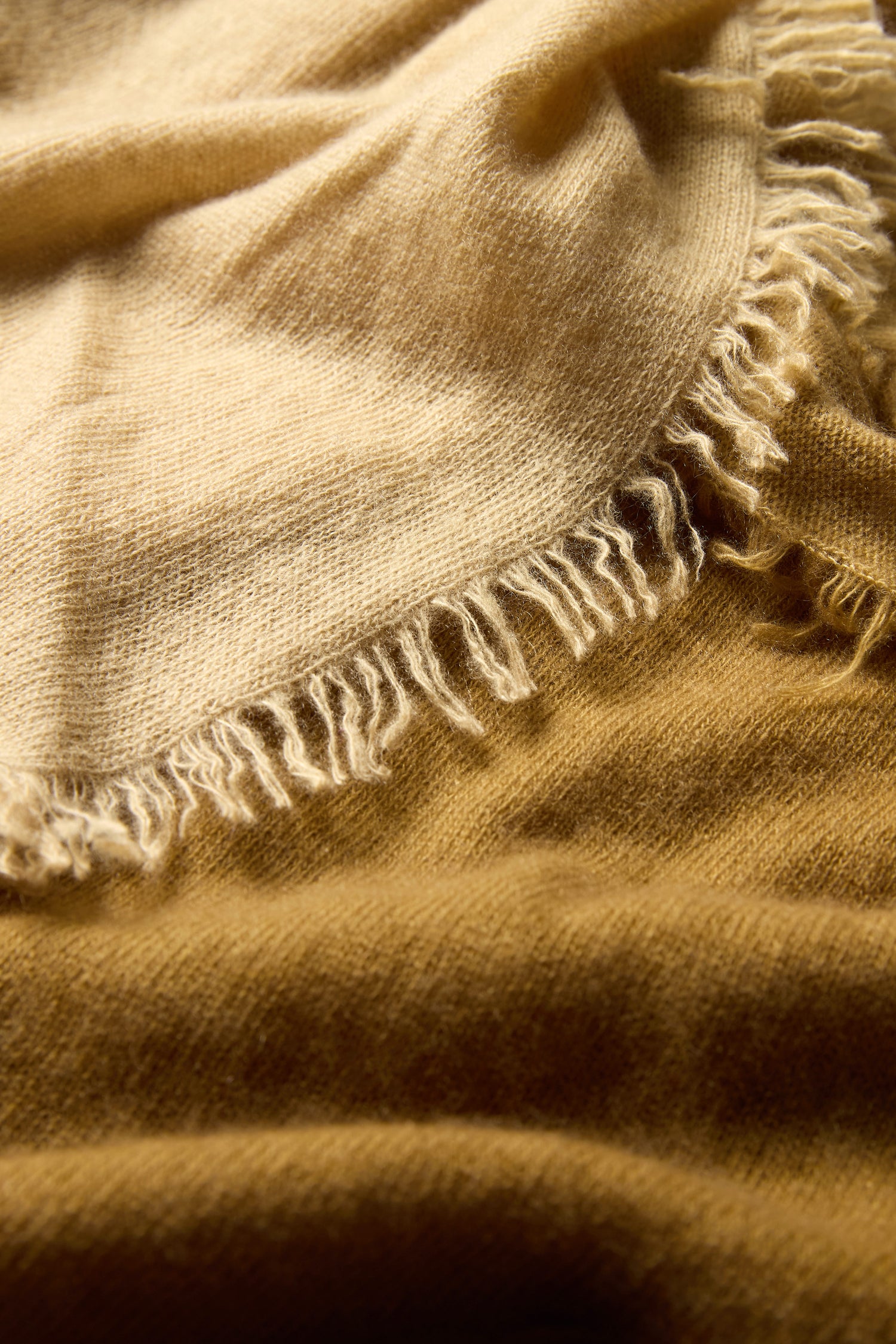 Close-up of the Ombre Cashmere Square Scarf, featuring a soft beige and brown weave, fringed edges, visible texture, and gentle folds.