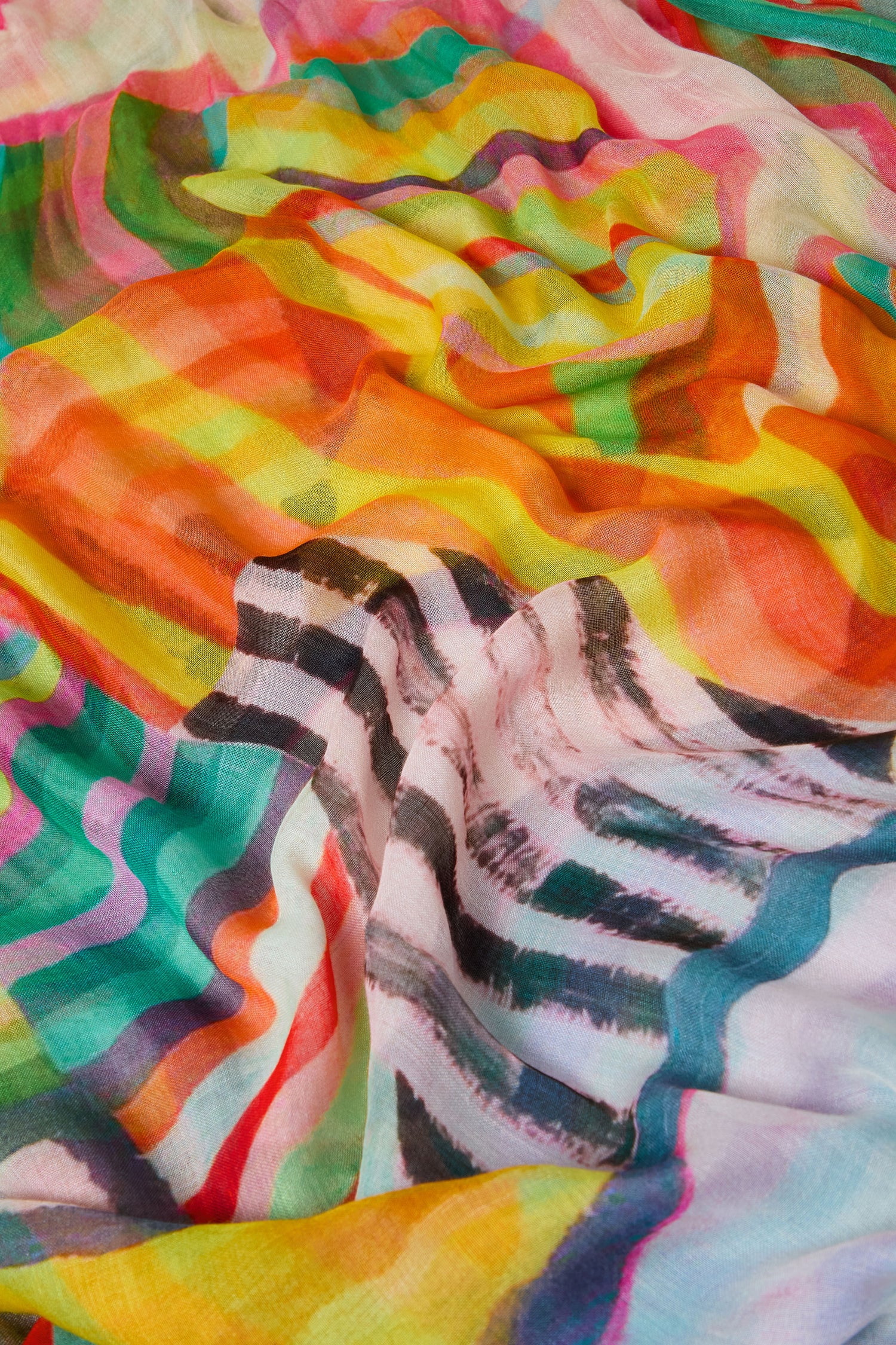 Close-up of the Directional Stripe Modal Blend Scarf, a lightweight accessory with vibrant wavy patterns in yellow, orange, red, green, pink, and black.