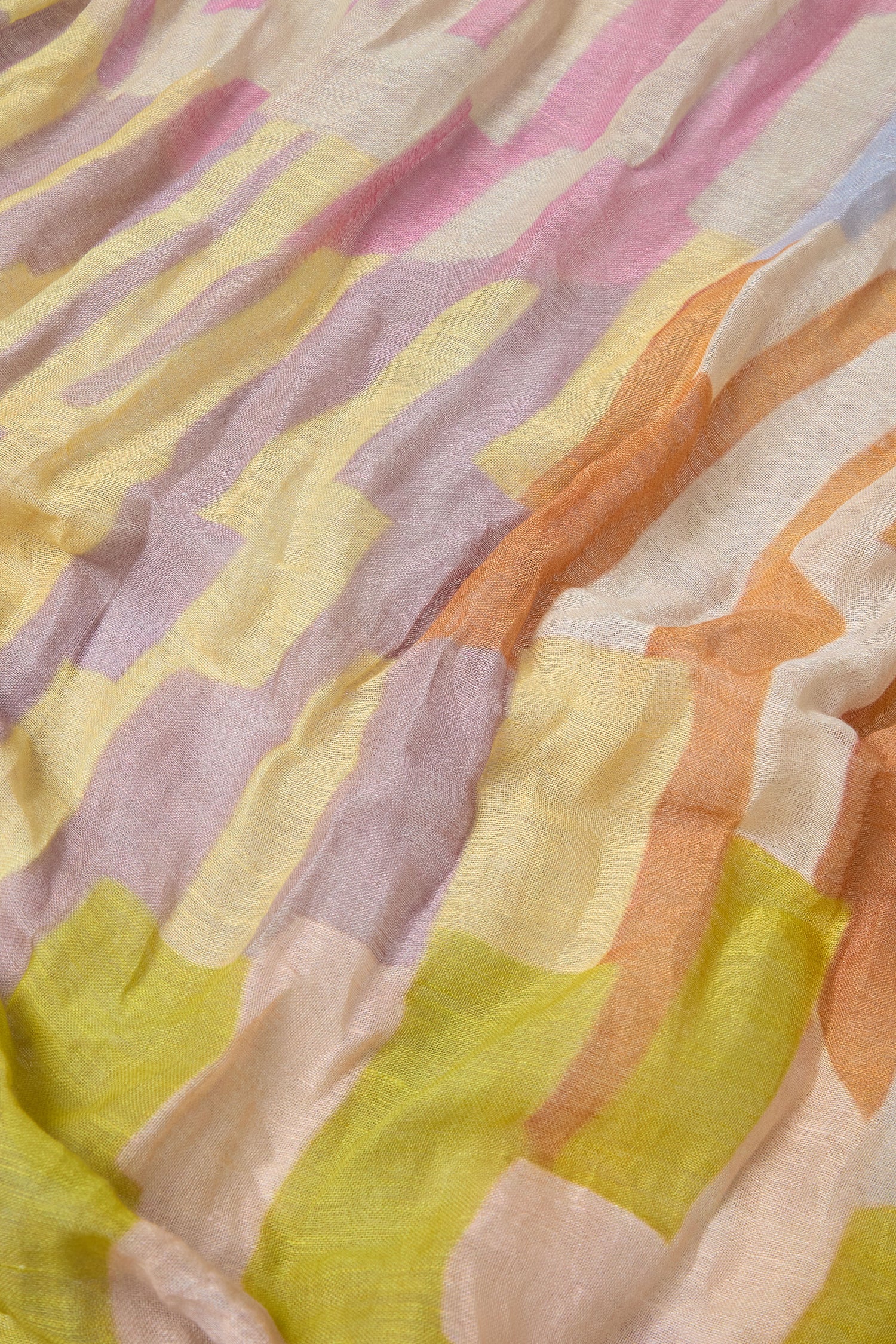 A close-up of the Soft Stripe Linen Blend Scarf shows its wavy abstract stripes in pastel yellow, pink, orange, and beige. The lightweight linen blend fabric looks soft and breathable—ideal for a comfortable scarf option.