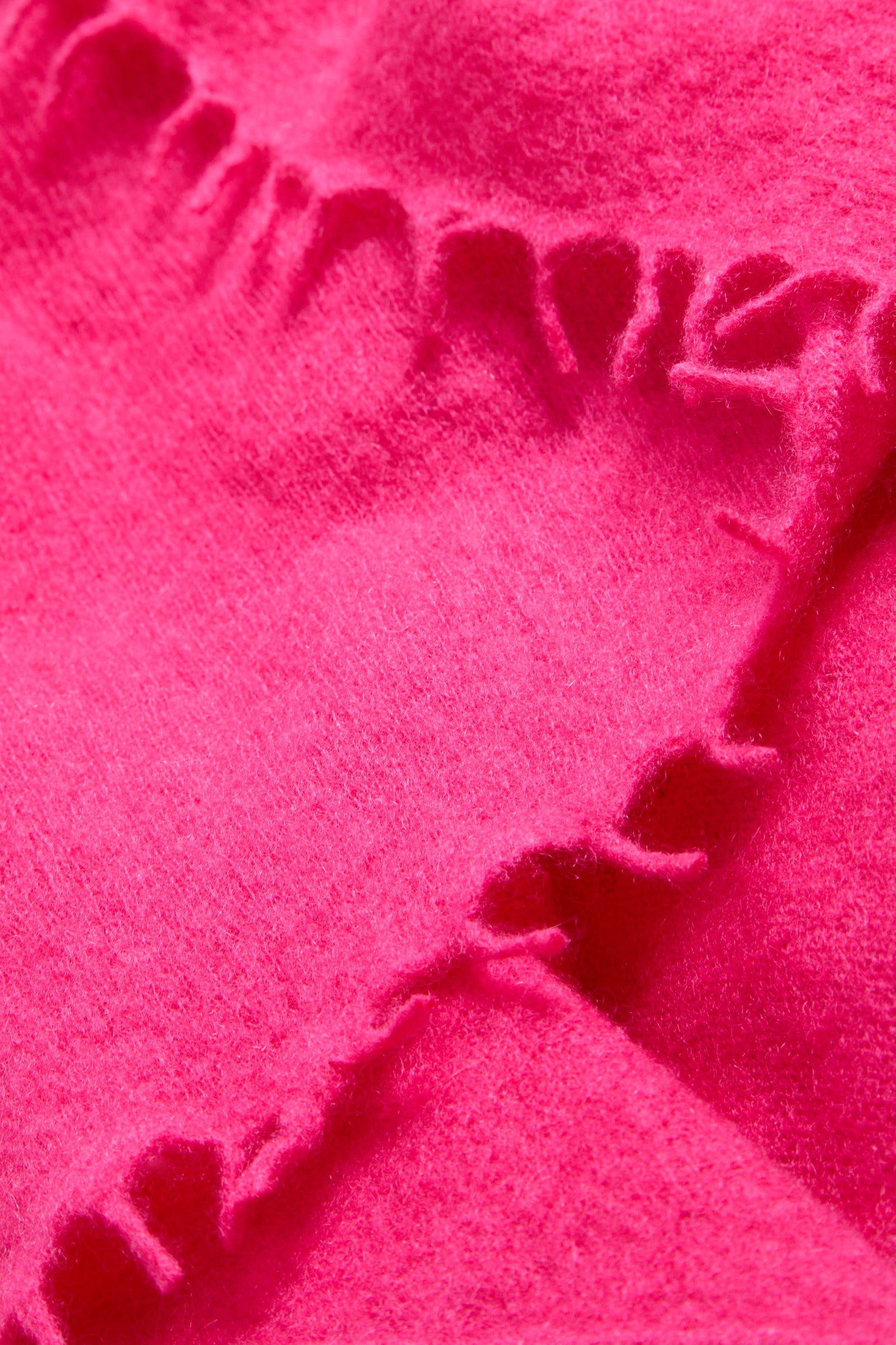 Close-up of the Fuchsia Soft Cashmere Scarf, showcasing its bright fuchsia fleece fabric with a scalloped stitched edge and visible soft texture, reminiscent of the luxurious feel of pure cashmere.