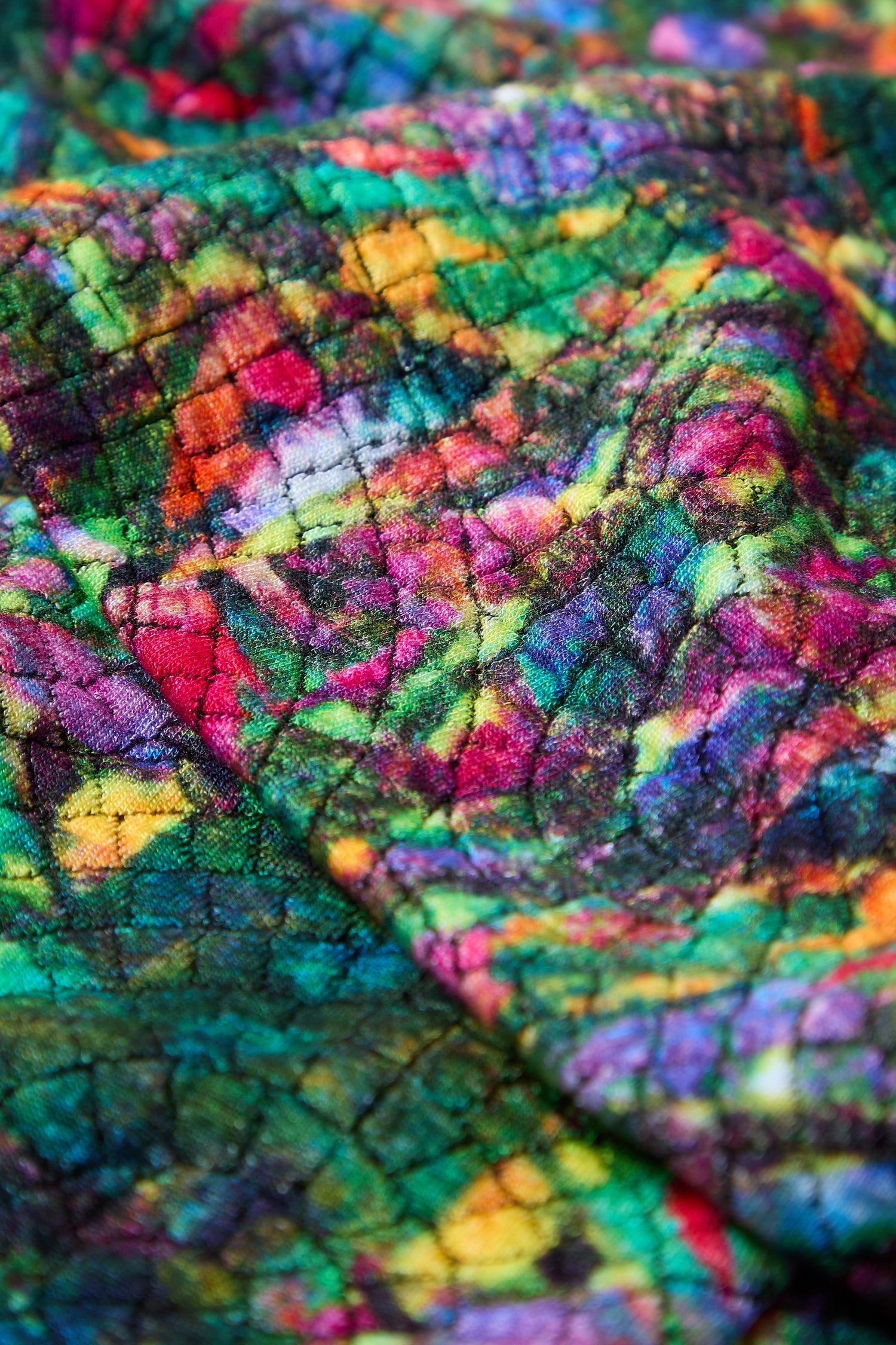 Close-up of the Circle Textured Snood, displaying a vibrant abstract pattern in green, red, yellow, pink, and blue on a slightly textured fabric—ideal for a stylish and versatile accessory.