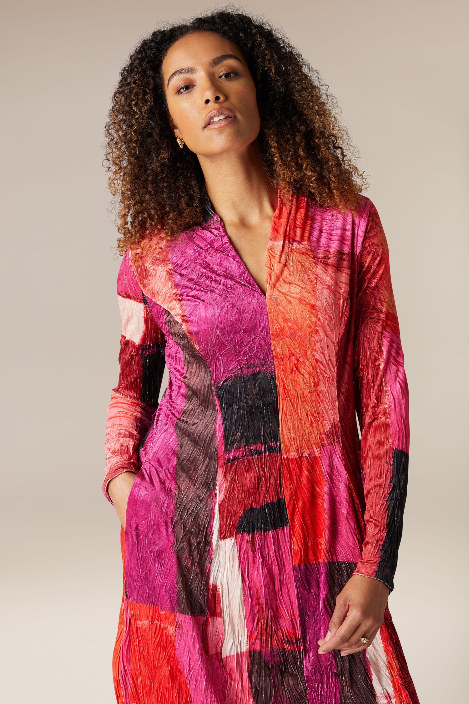 A woman wearing a Block Velvet Dress in pink and red.