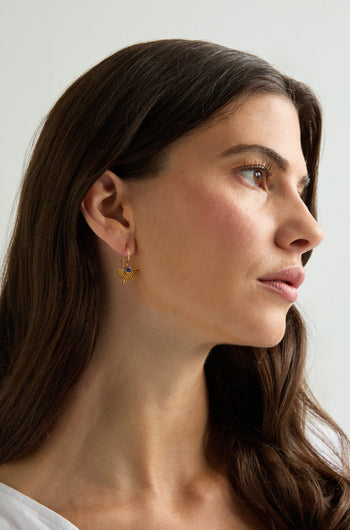 A woman with long brown hair in a white top wears Gold Vermeil Lapis Fan Earrings, looking to the side against a neutral background.