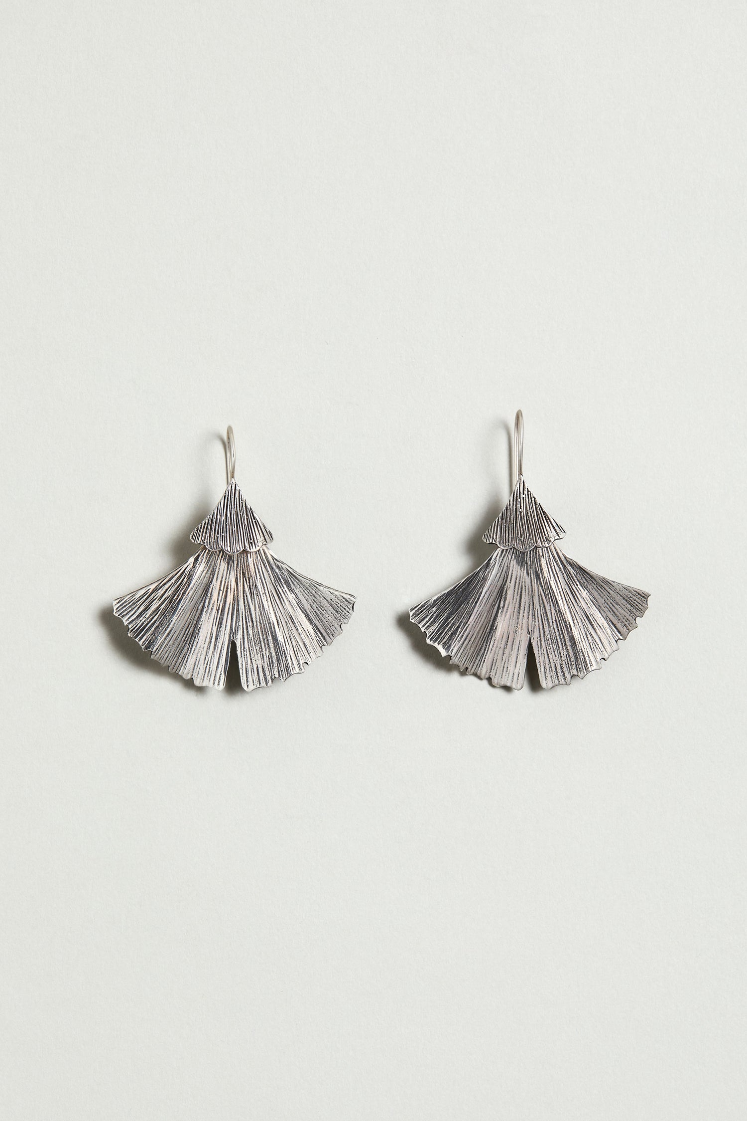 Silver Ginkgo Leaf Earrings featuring a textured, fan-like design, shown on a simple light background.