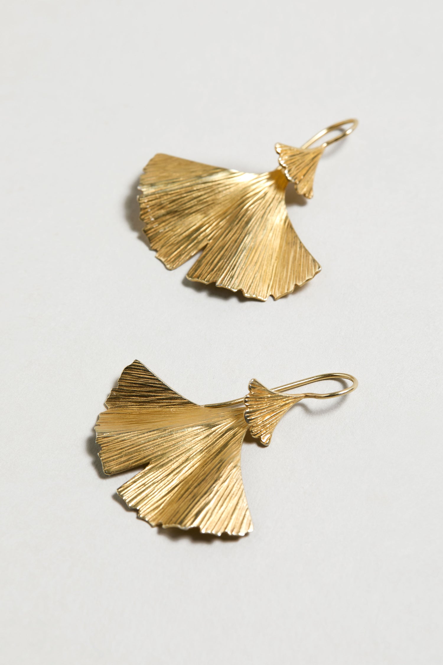 Gold Vermeil Ginkgo Leaf Earrings with textured, intricate detailing, inspired by ginkgo leaves and displayed on a light surface.