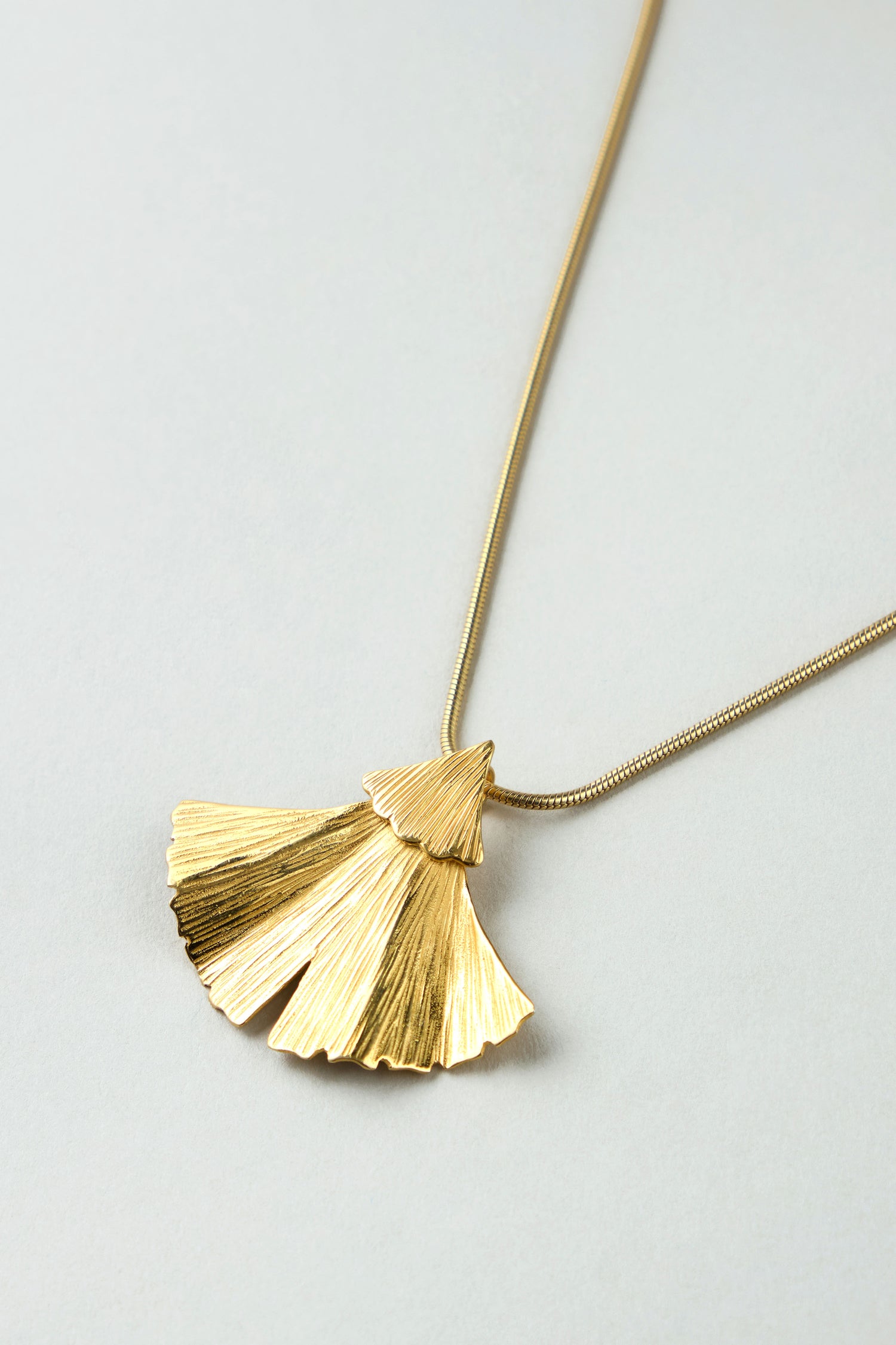 Gold Vermeil Ginkgo Leaf Pendant featuring a fan-shaped, textured design on a fine chain, shown against a neutral background.