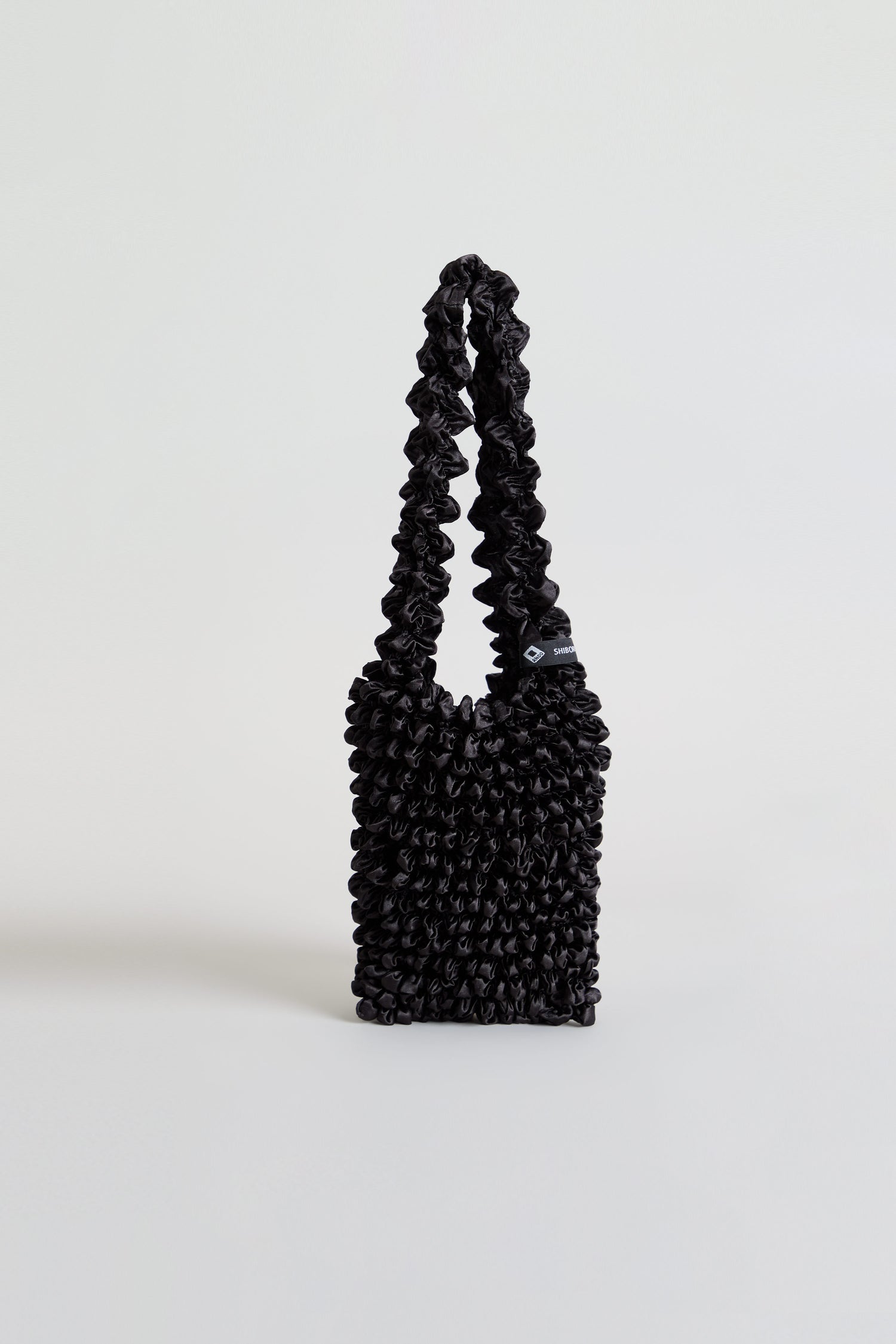 Black Shibori Pleated Bag with a ruched texture and a matching gathered shoulder strap.