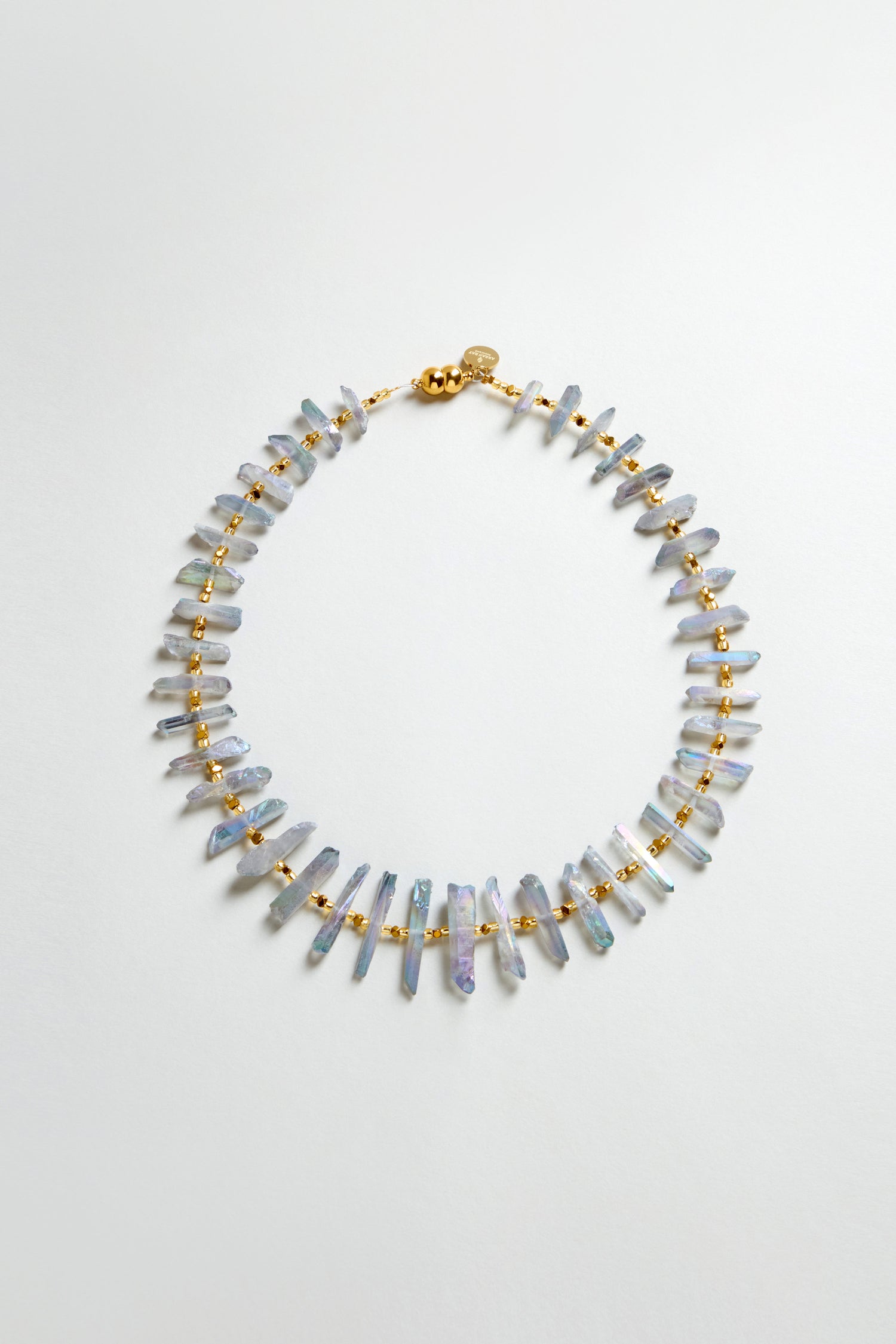The Slate Quartz Necklace is a gold-plated statement piece with evenly spaced, irregularly shaped light purple quartz beads, shown on a plain white background.