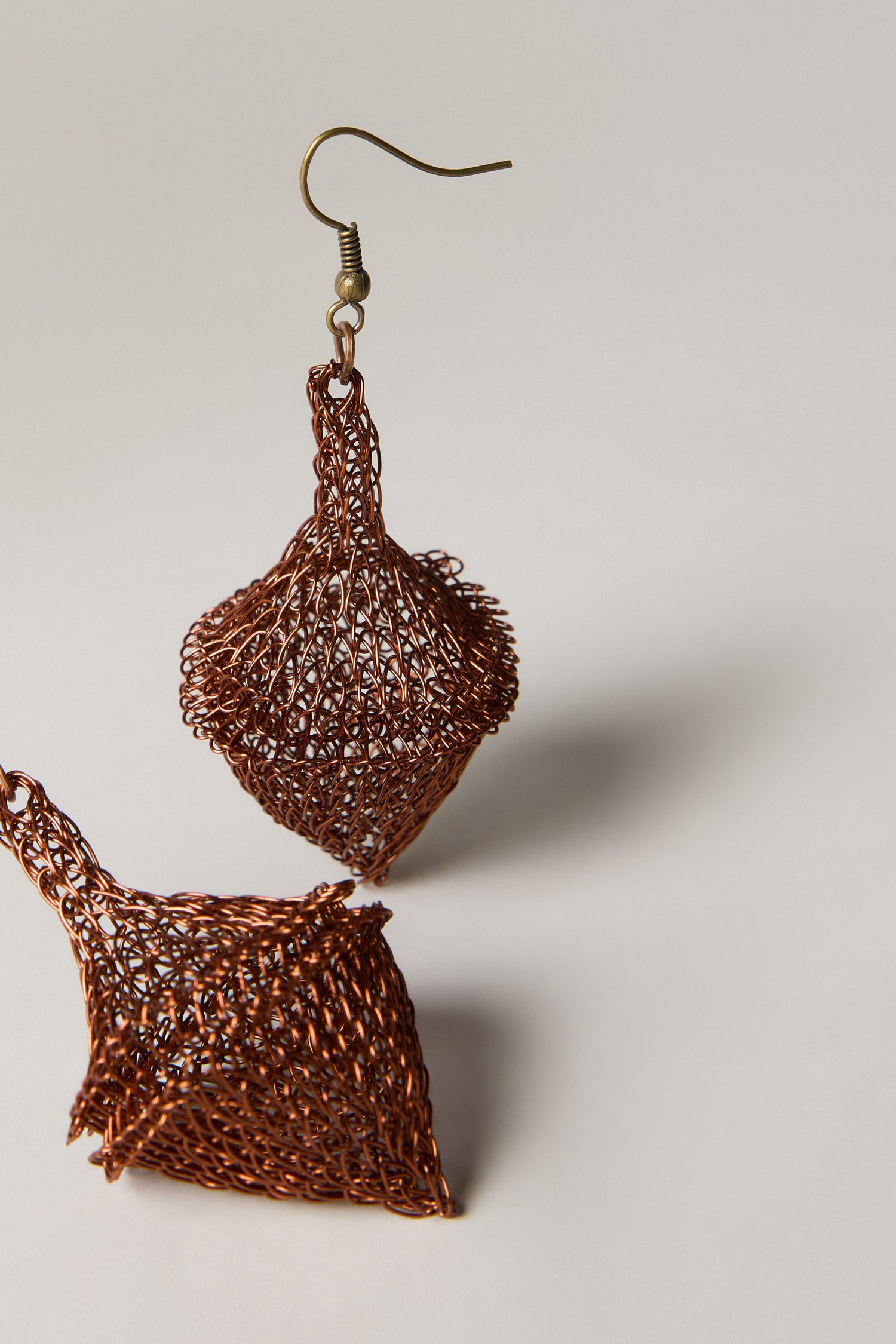 Hand Crocheted Earrings crafted from copper-colored metal with geometric, cone-like shapes, displayed on a neutral background.