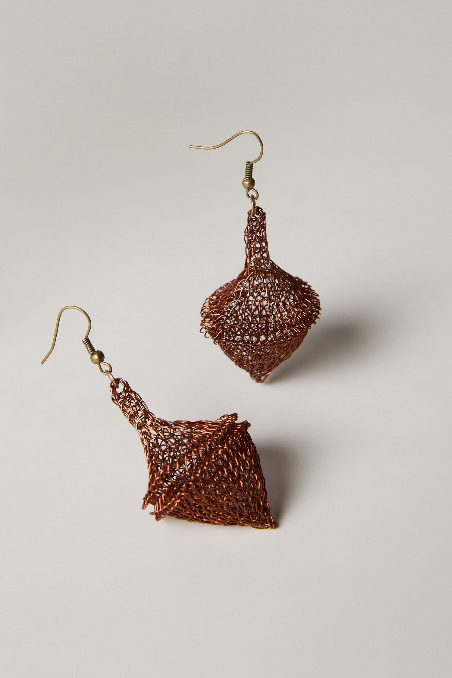 Hand Crocheted Earrings featuring copper wire mesh and diamond-shaped geometric designs, showcased on a simple light background.