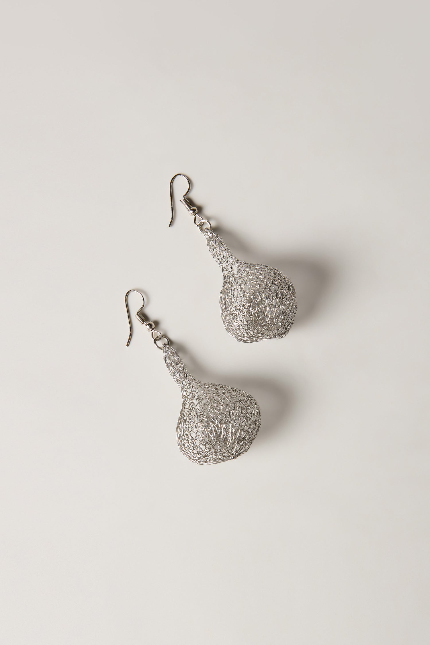 A pair of Hand Crocheted Teardrop Earrings with a silver wire mesh design and artisanal craftsmanship, displayed on a plain light background.
