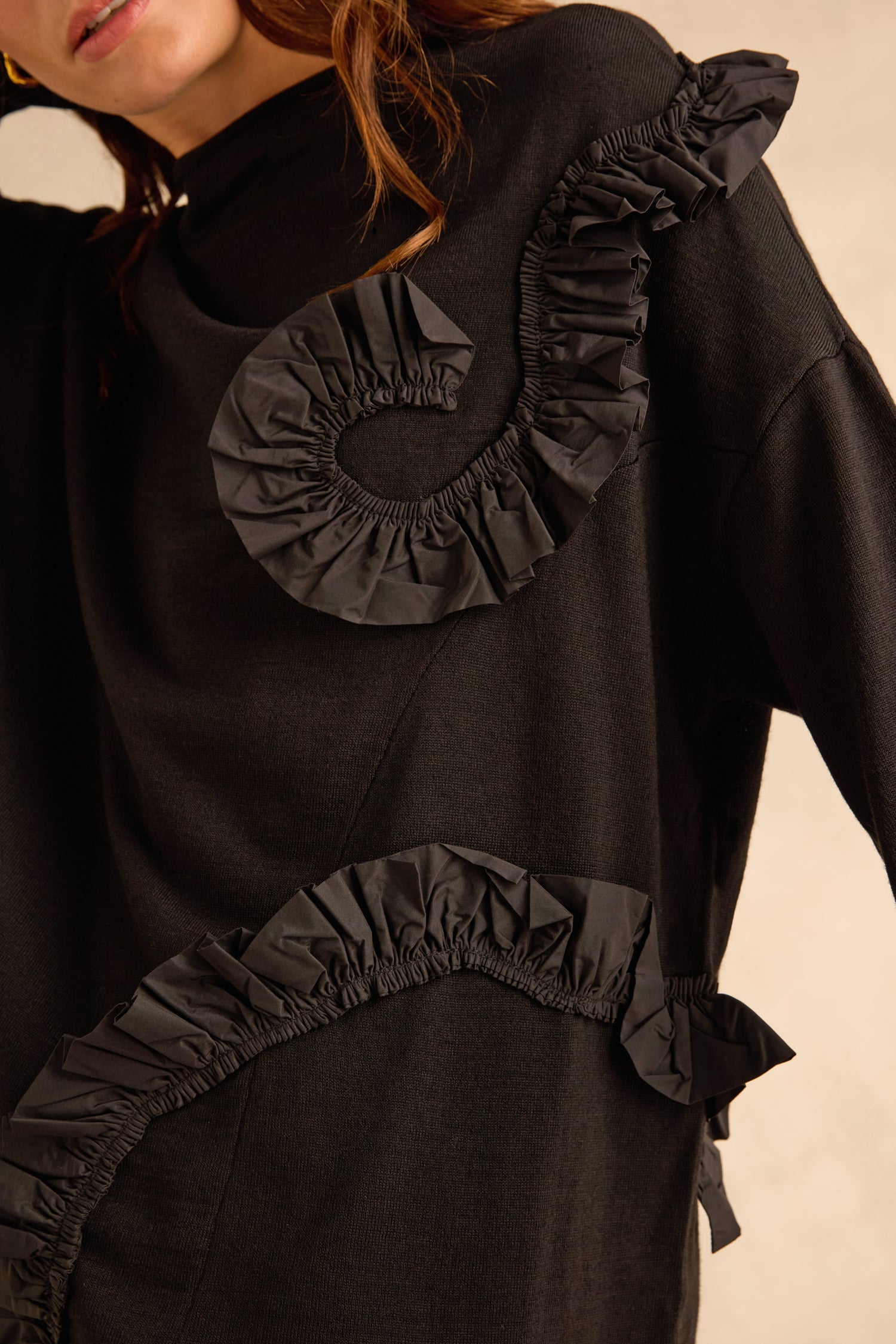Taffeta Detail Knit Top in a black, relaxed-fit knit featuring swirling taffeta ruffle appliqué across the chest and side.