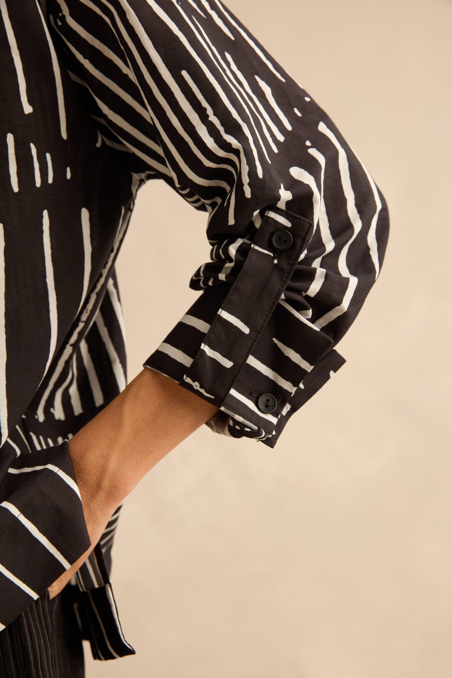Linear Shirt With Flower Pin: black cotton shirt with a white vertical linear print and buttoned cuffs.