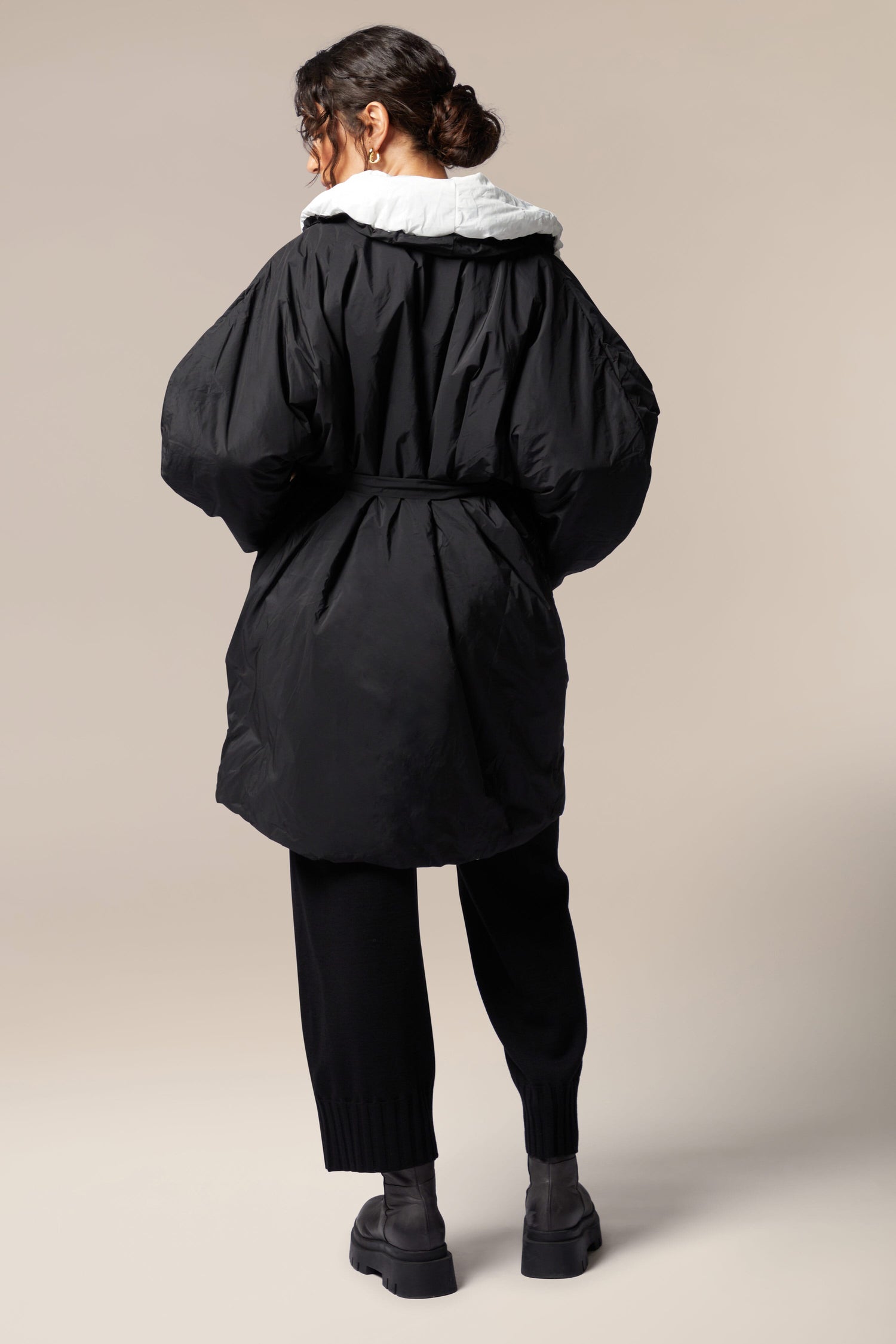 The back view of a woman wearing a Reversible Puffa with a flower applique.
