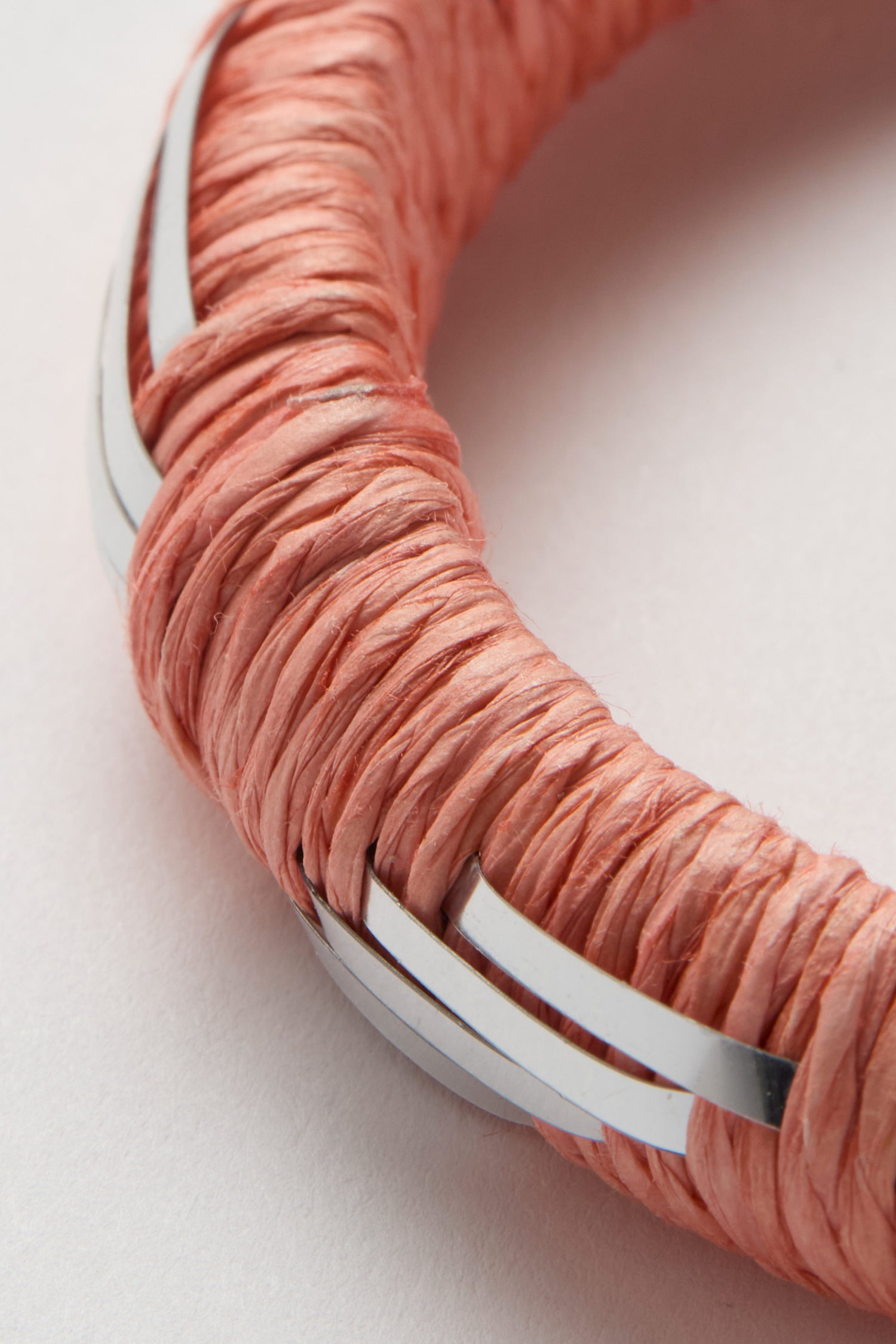 Close-up of the Handwoven Silver Chevron Bangle in pink with silver accents, shown on a white background.