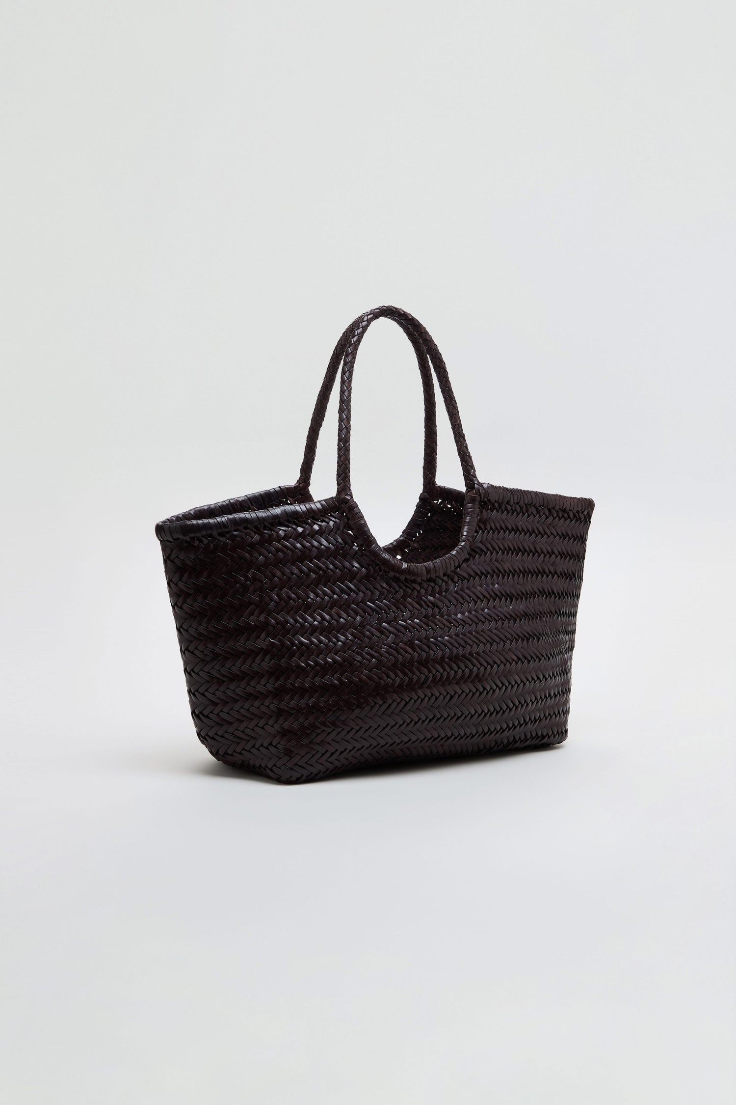 The Nantucket Woven Dark Brown Leather Bag, featuring two handles, is displayed against a plain light background.