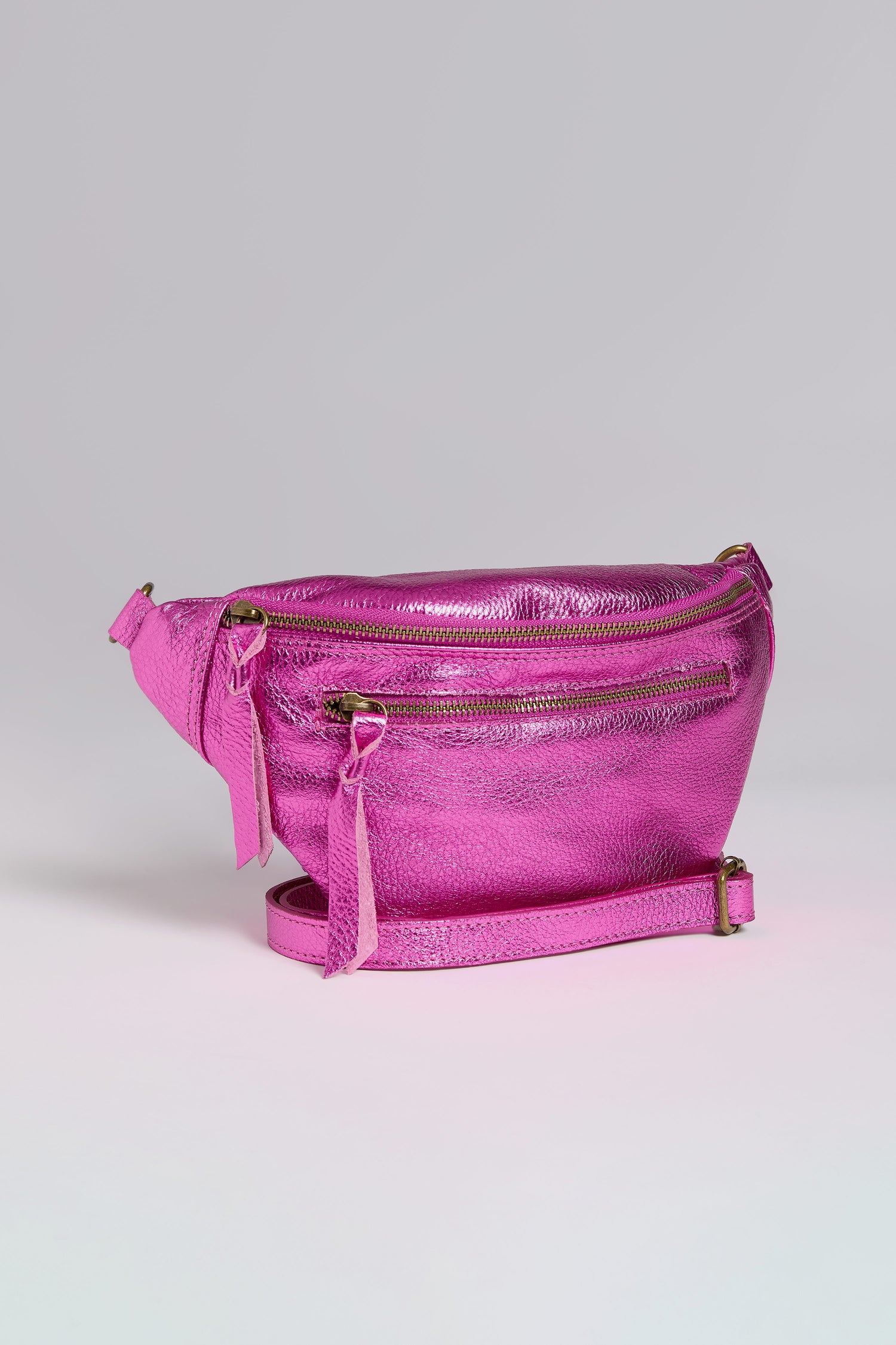 Metallic leather crossbody bag with multiple zippers and a strap, displayed on a neutral background.