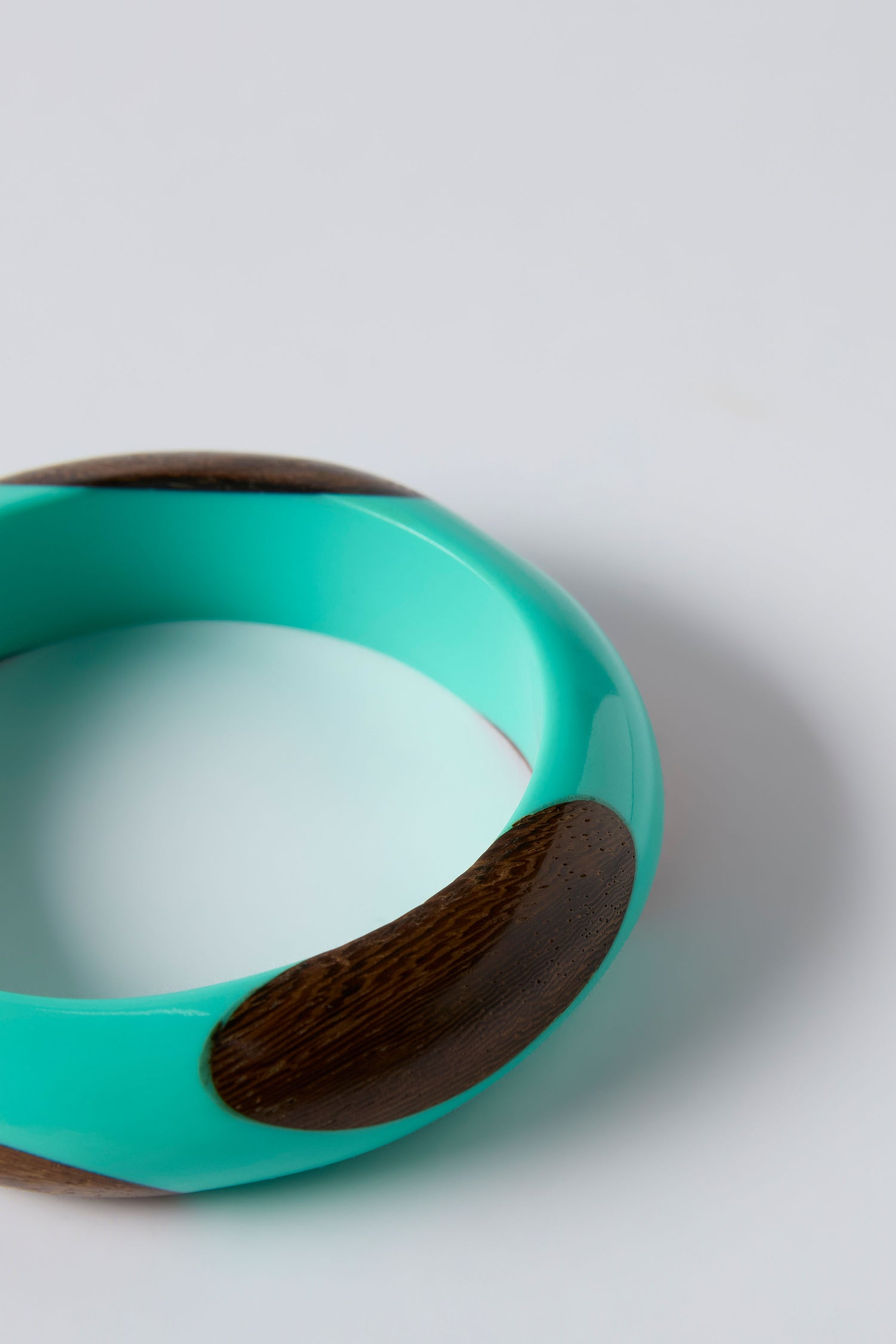 The Dotty Turquoise Wooden Bangle is a striking statement piece with dark brown wooden inlays, showcased on a plain light background.