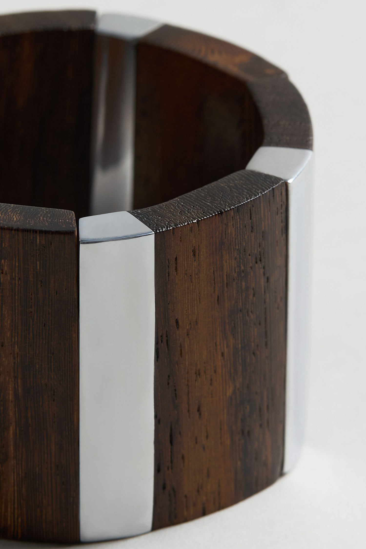 The Textured Wooden Bracelet by Ernesto de Barcelona features chunky, alternating dark wood and shiny silver metal segments—an eye-catching piece of handmade jewelry.
