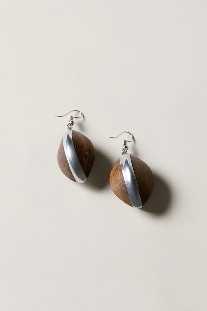 Wooden Oval Pebble Earrings featuring handcrafted oval wooden beads with diagonal silver stripes and silver hooks, elegantly displayed on a light background.