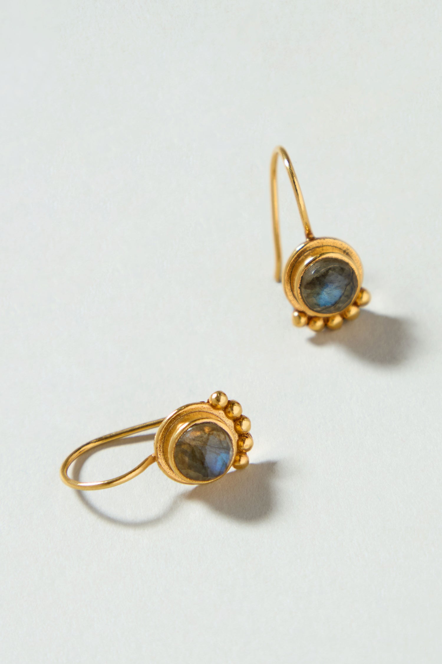 Labradorite Stone Earrings: Handcrafted gold-plated earrings feature round bezel-set labradorite stones accented with small gold beads, shown against a light background.