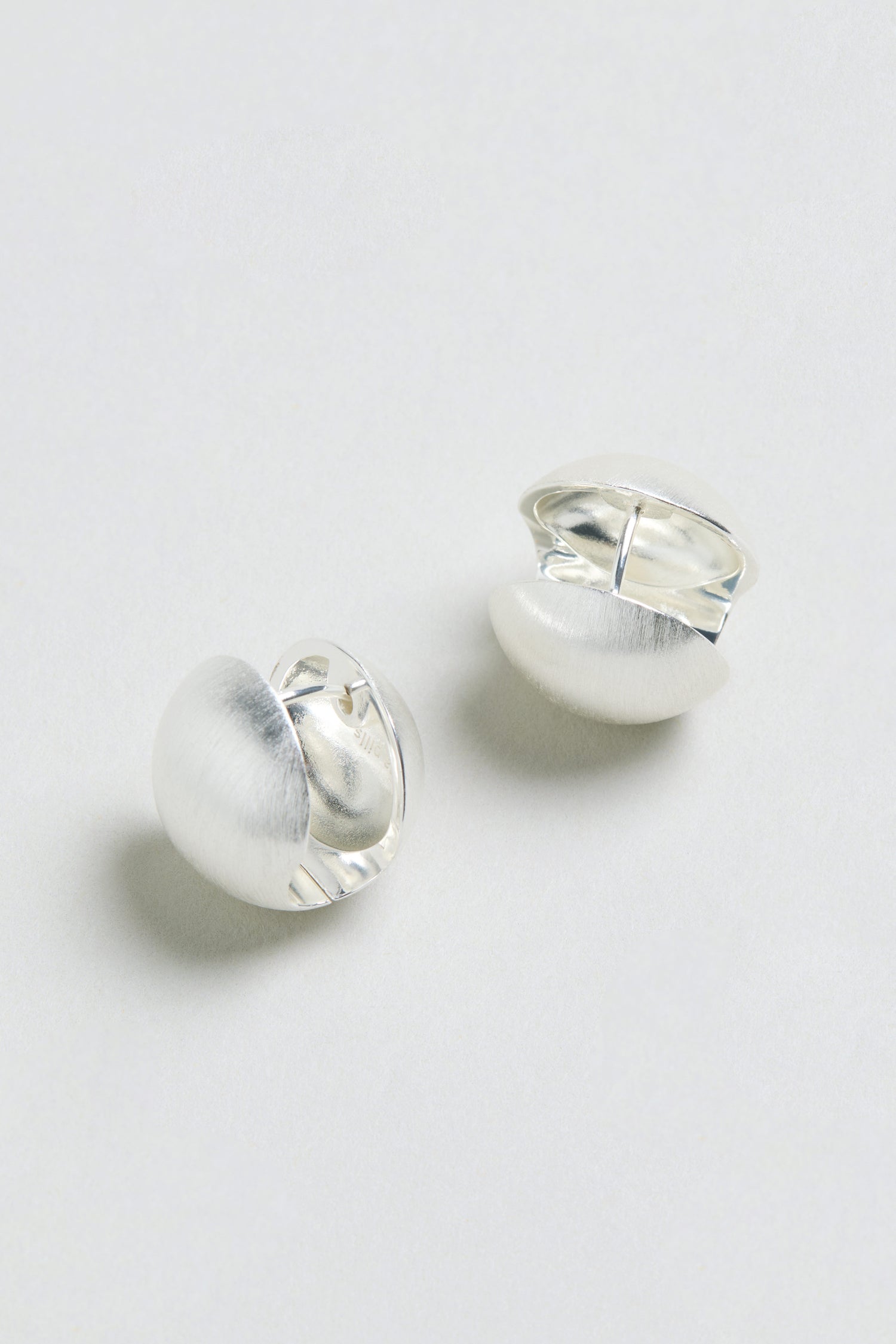 Brushed Sphere Earrings—round, silver-plated studs with a matte finish—displayed on a light, plain background.