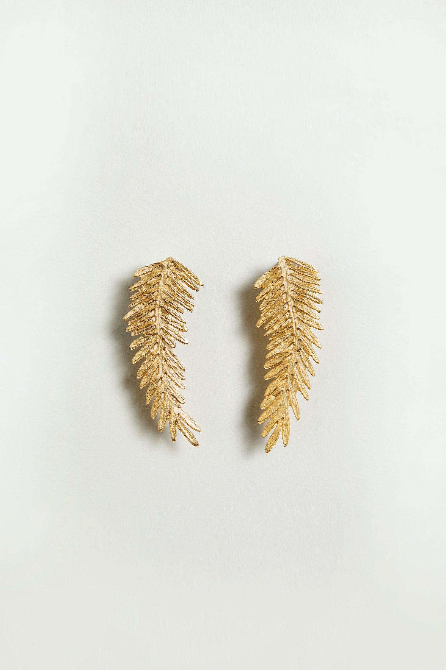 A pair of Gold Plated Feather Earrings displayed on a plain light background.