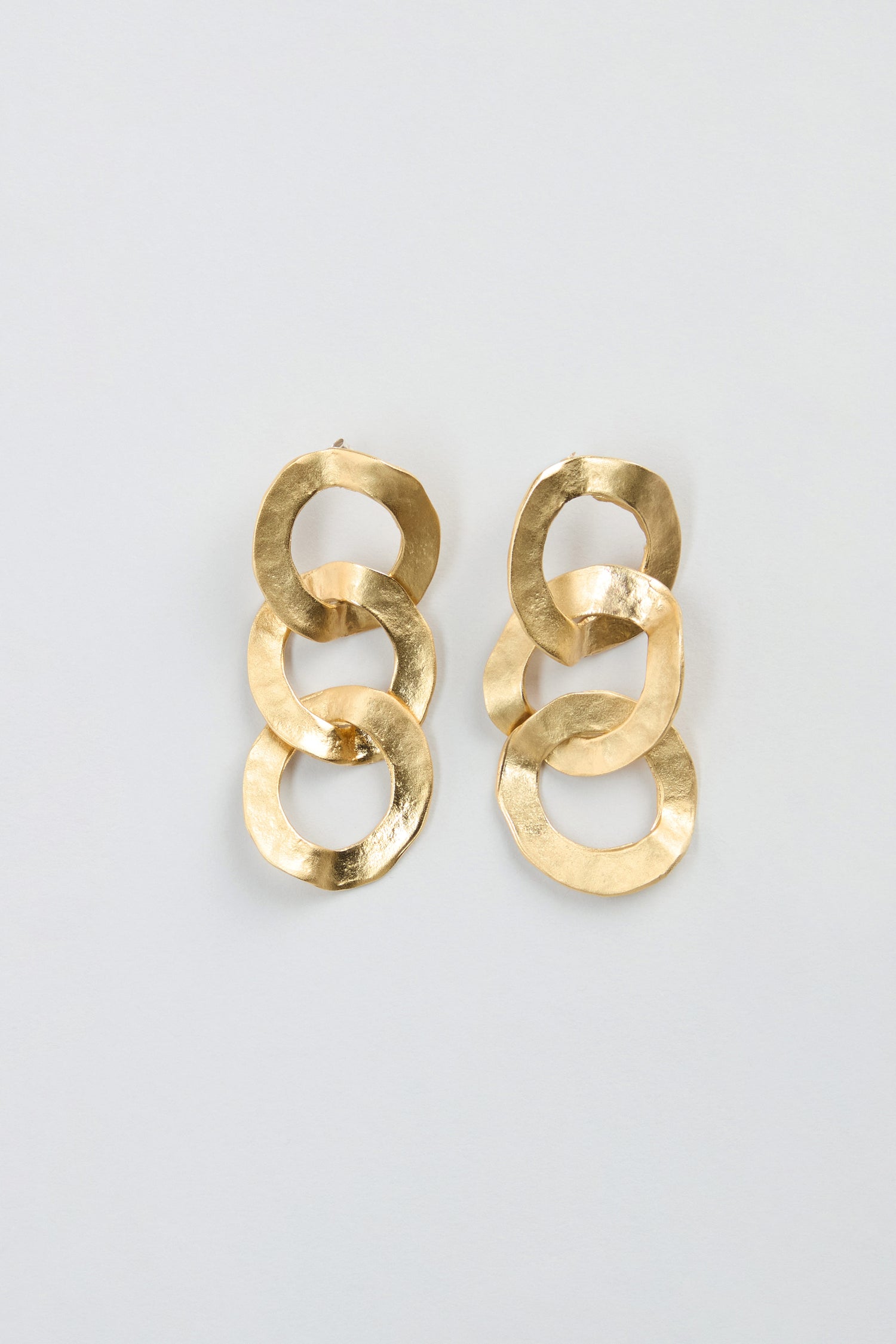 Gold Triple Hoop Earrings featuring three interlocking, textured gold hoops per earring, displayed against a plain light background—these statement drop earrings are the perfect accessory to elevate any look.