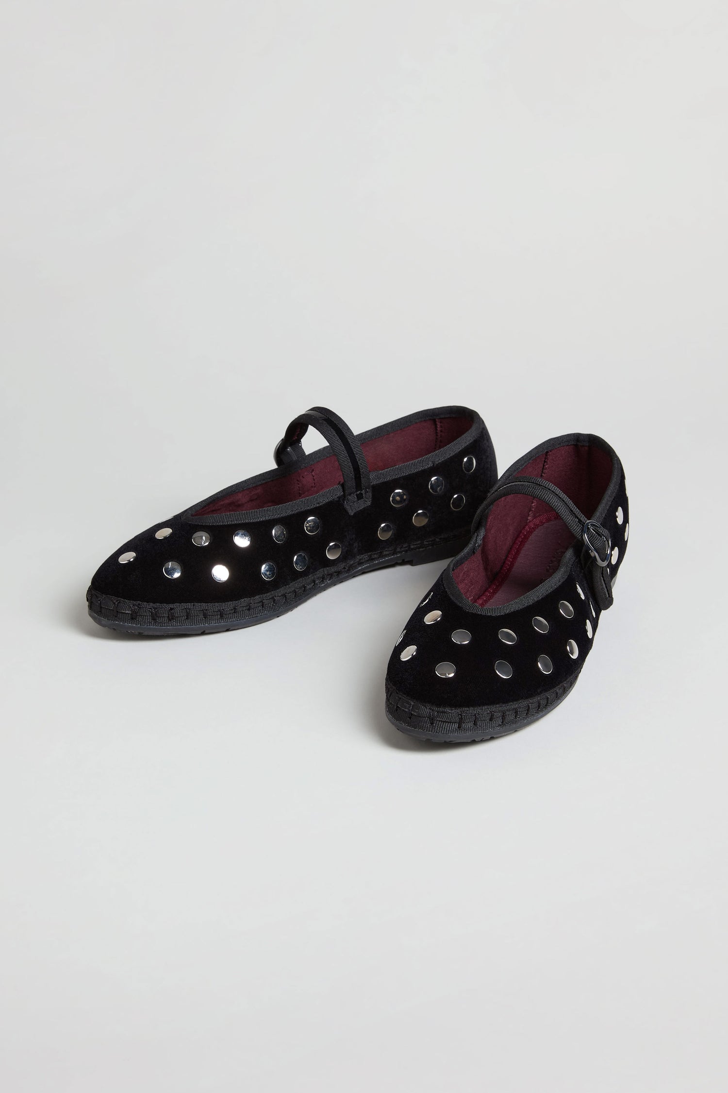 Studded Mary Jane Velvet Shoes: handmade black velvet shoes with silver circular studs and a strap, blending classic Spanish craftsmanship with modern style. Displayed on a white background.