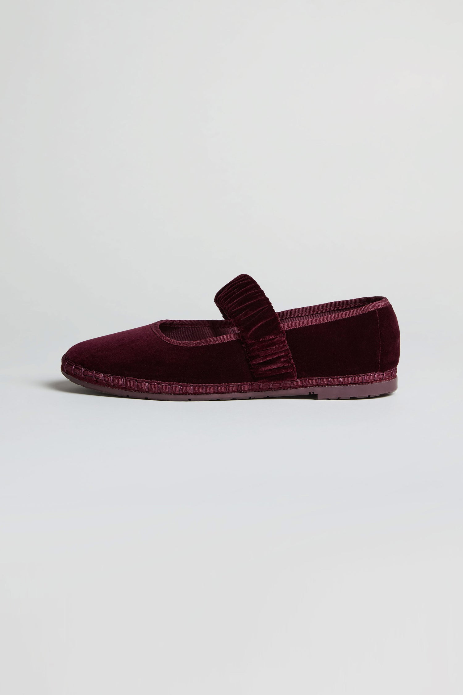 A single Mafalda Wine Velvet Shoe, handcrafted in Spain, features a textured strap and is displayed on a plain light background.