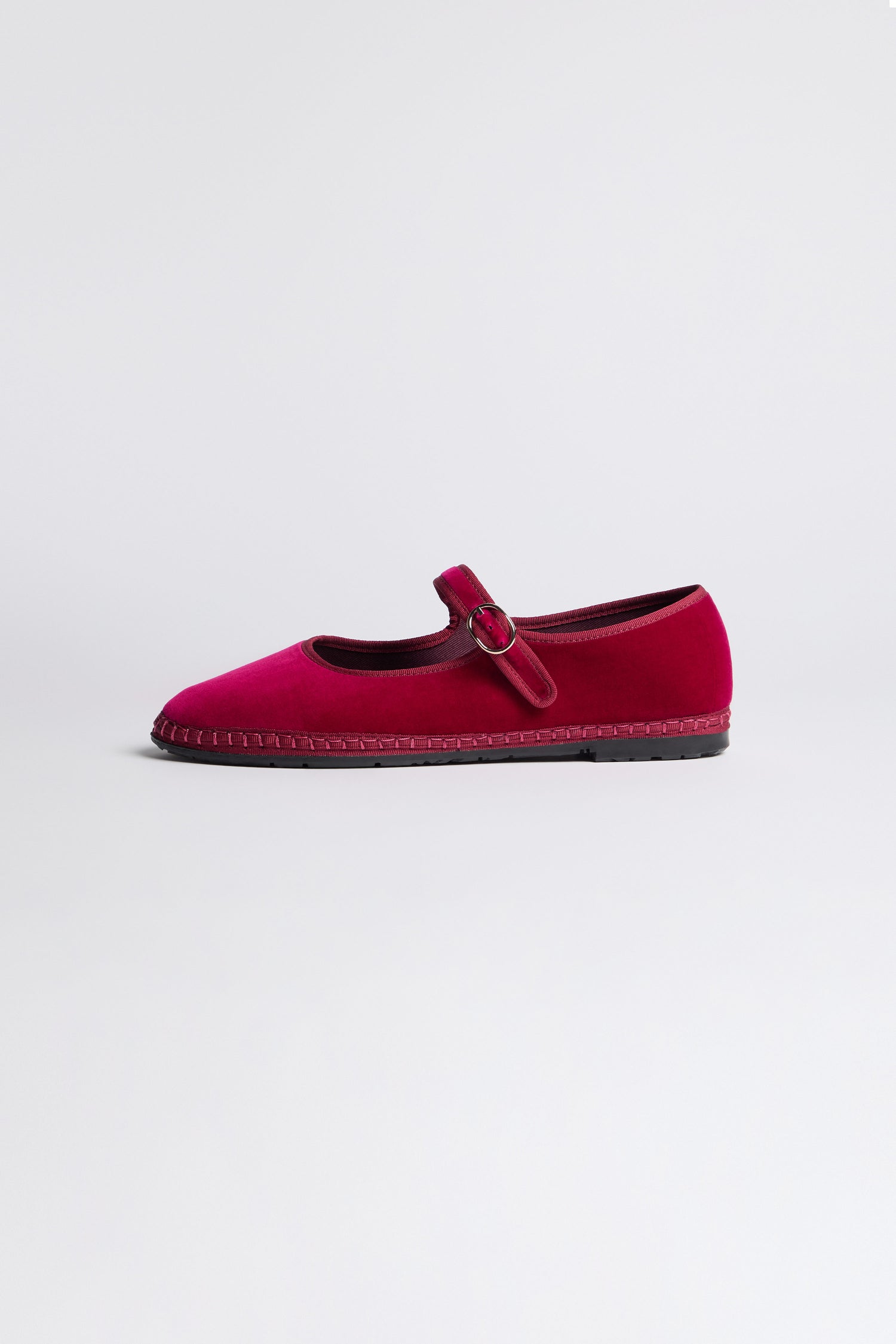 A single Fuchsia Mary Jane Velvet Shoe with a buckle strap is displayed on a plain white background, showcasing its vintage charm and timeless elegance.
