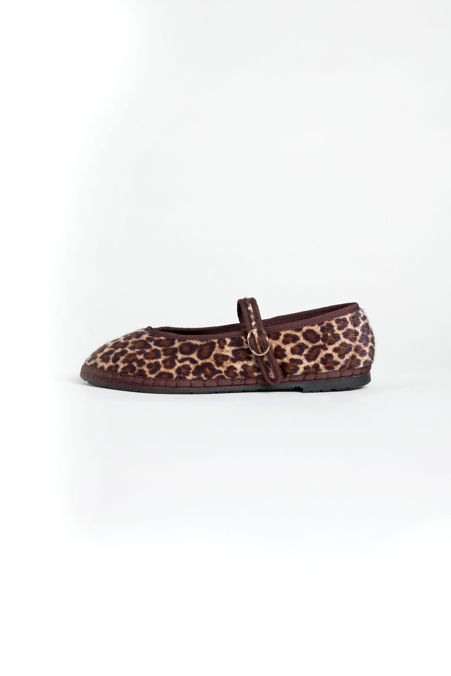 A single Cheetah Mary Jane Shoe with a leopard print, small buckle strap, and recycled bicycle tire sole, handmade in Spain, is shown on a white background.