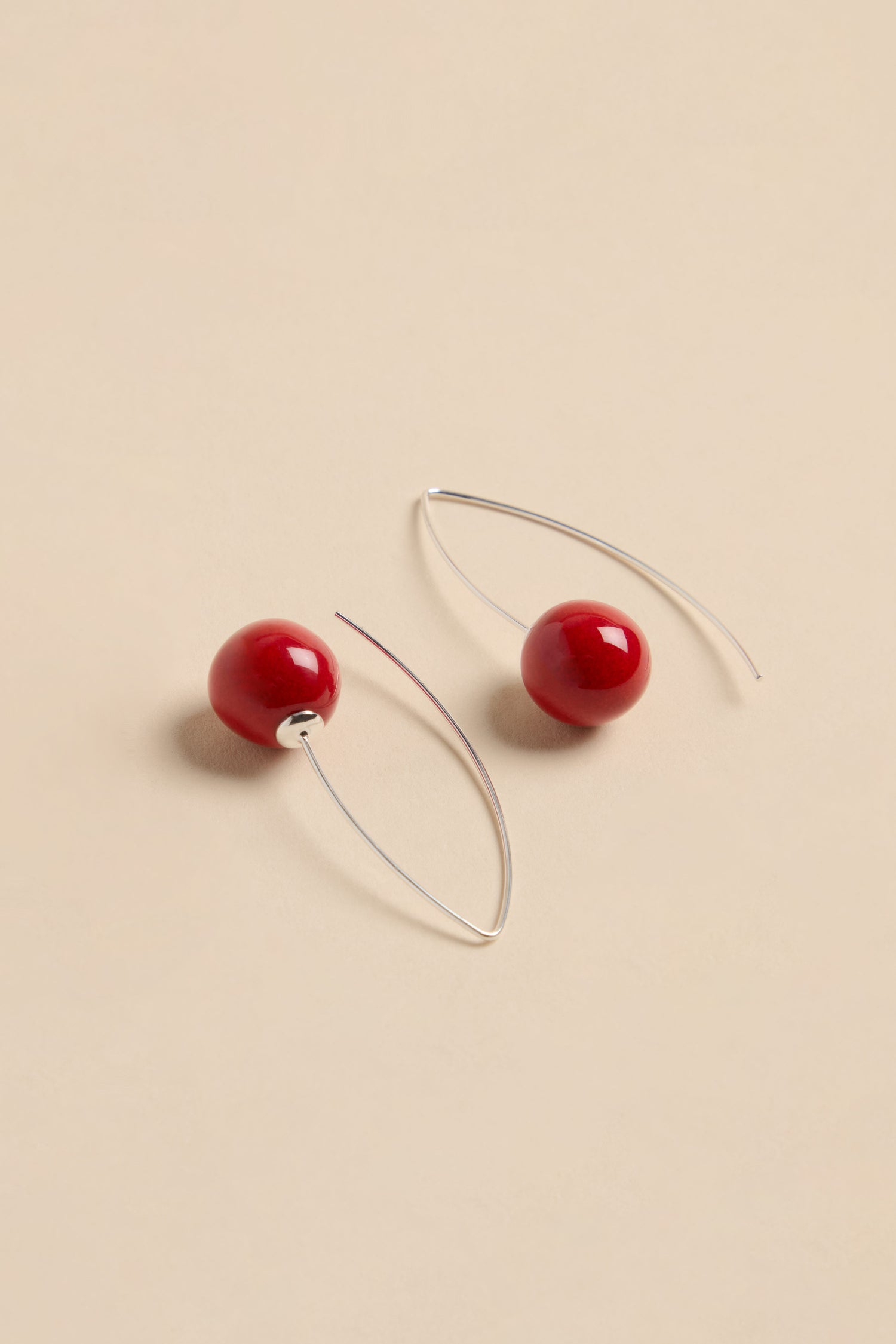 Handmade Deep Red Ceramic Bead Earrings featuring round red ceramic beads on silver wire hooks.