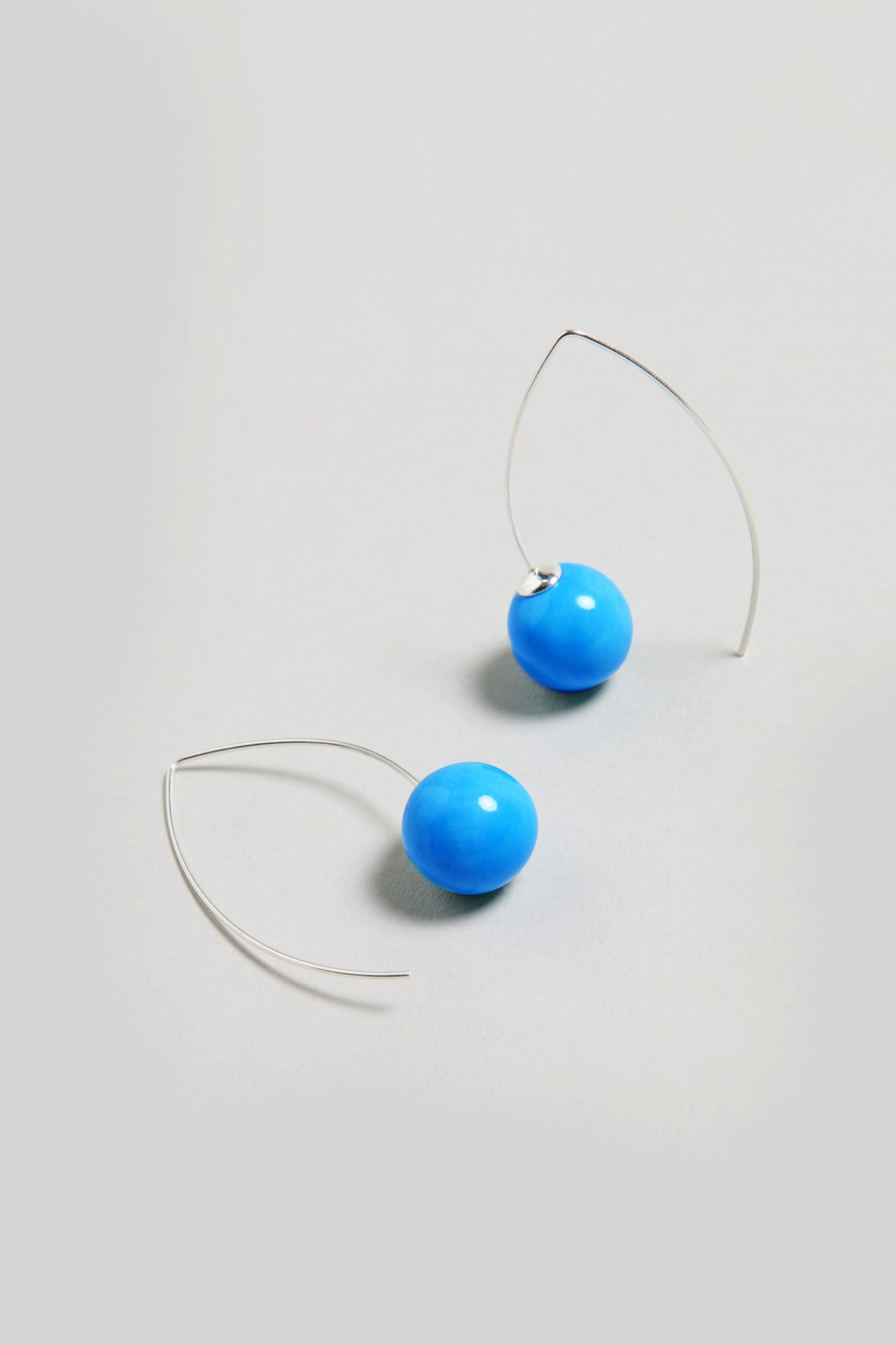 Handmade Ceramic Bead Earrings with turquoise round beads and silver hooks, displayed on a light grey background.