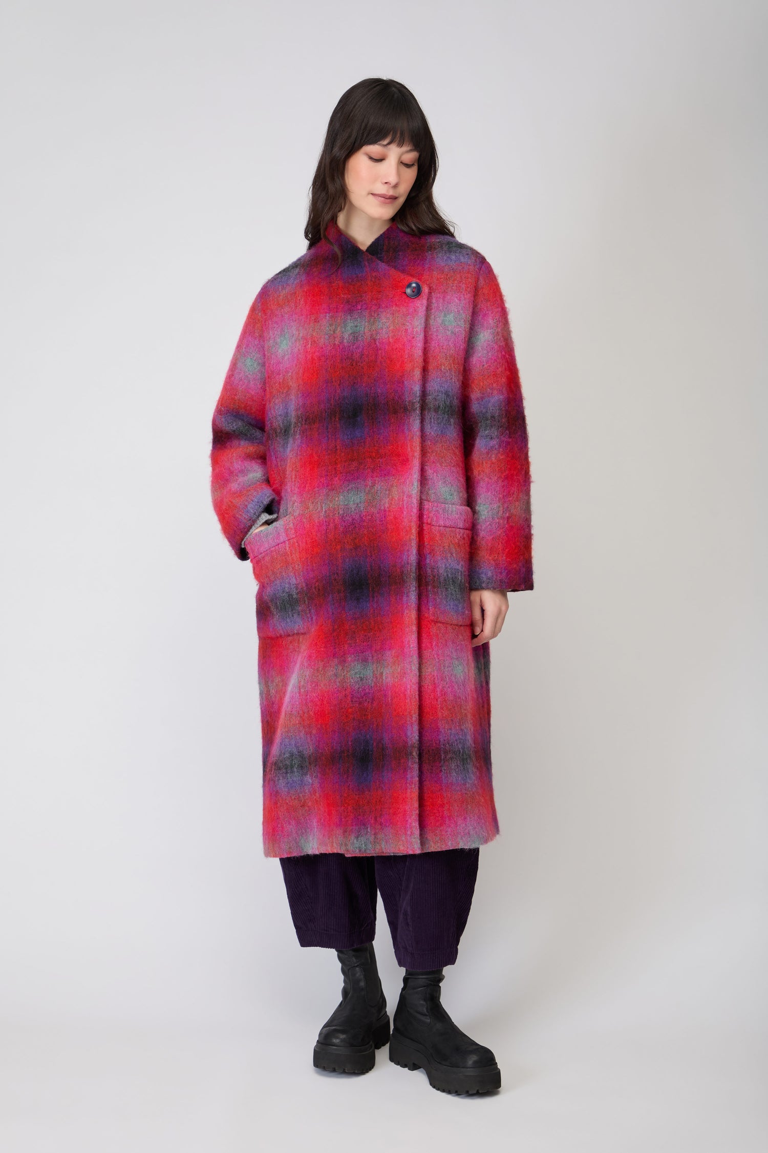 Close-up of a woman wearing the Bright Brushed Check Wool Coat, an oversized women's coat with a colorful plaid pattern, high collar, and single button detail near the shoulder.