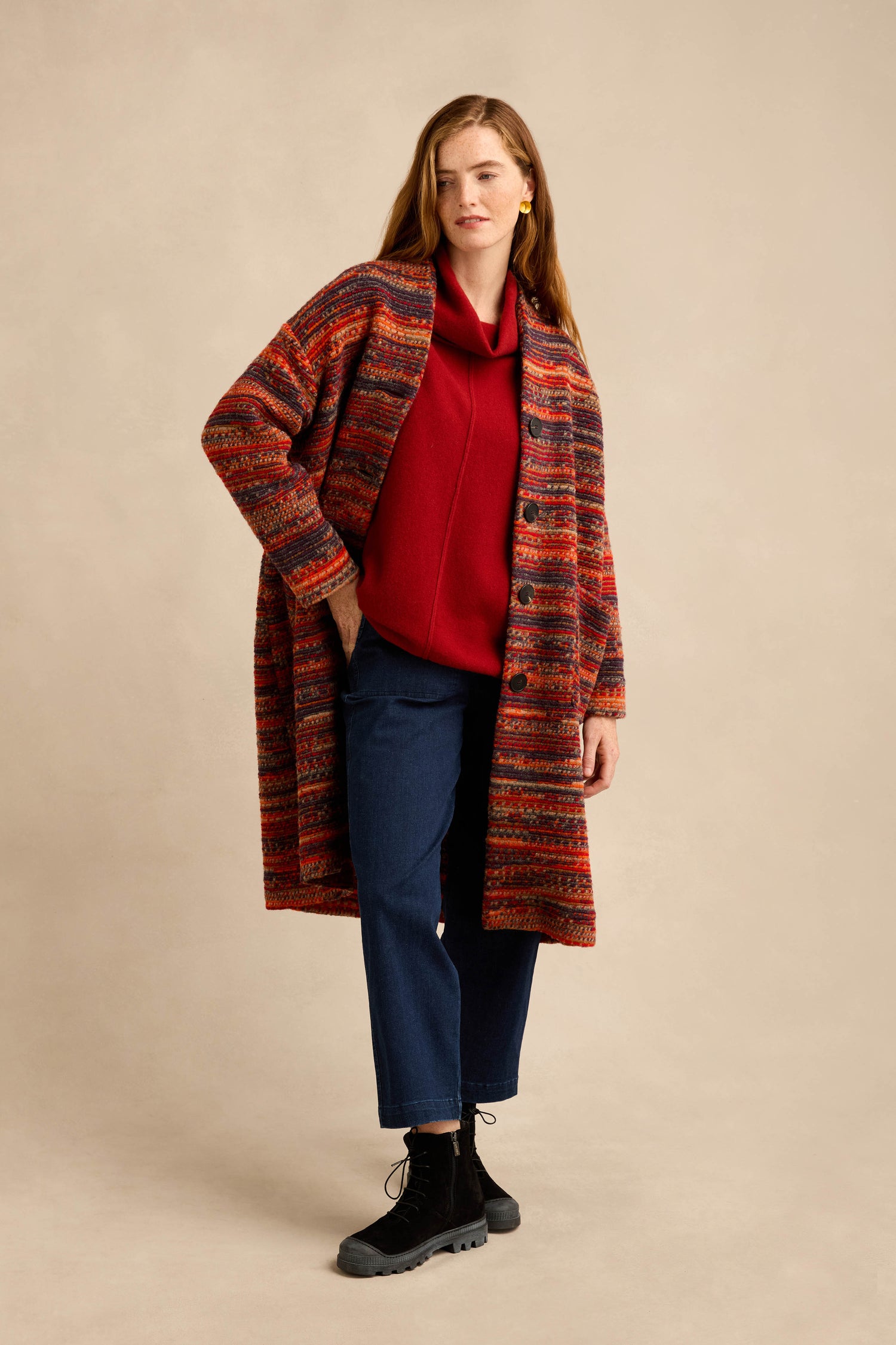 A woman wearing the Artisan Wool Blend Stripe Coat over a red sweater, blue jeans, and black lace-up boots stands against a neutral background.