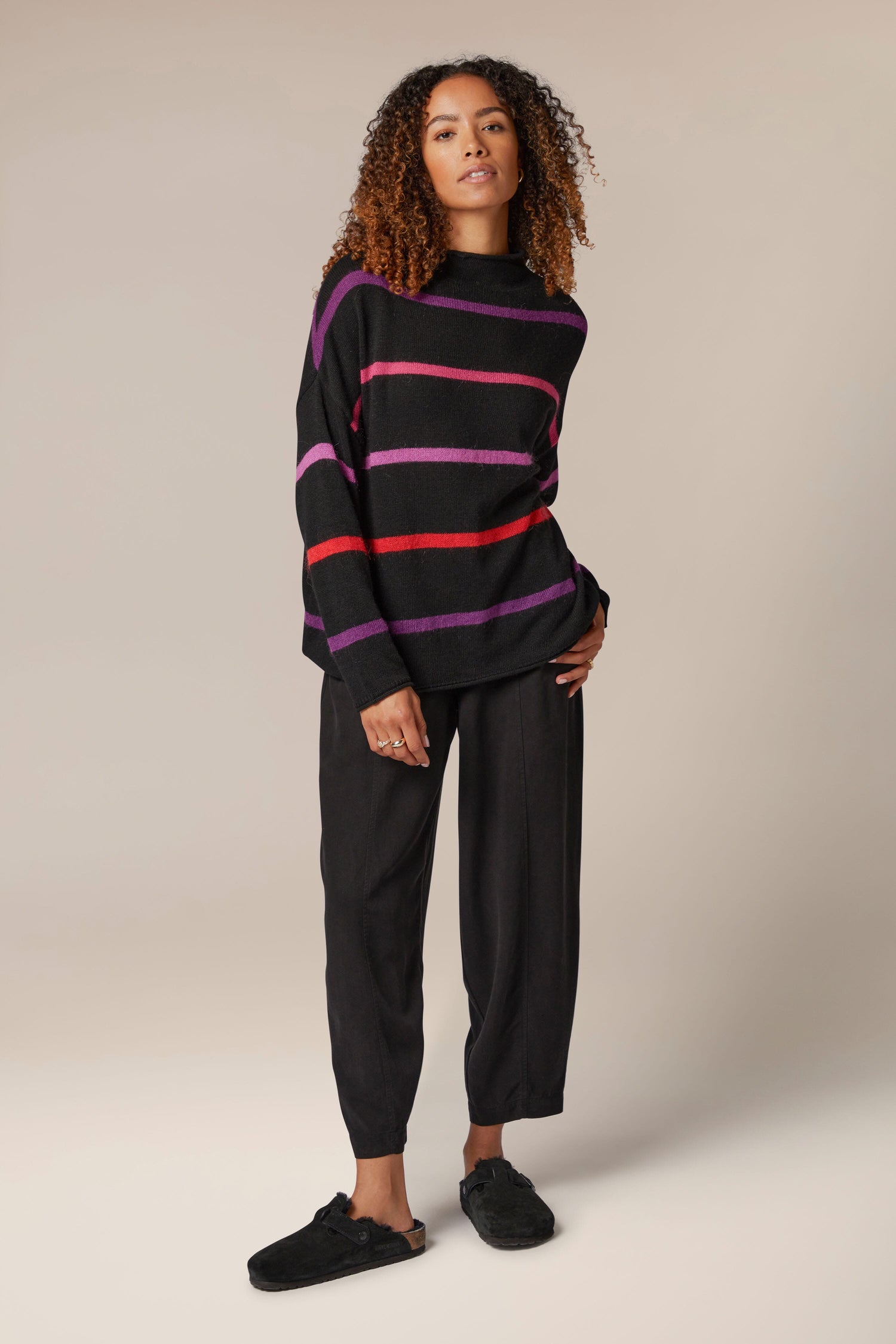 A woman wearing a Mohair Blend Stripe Sweater and pants.