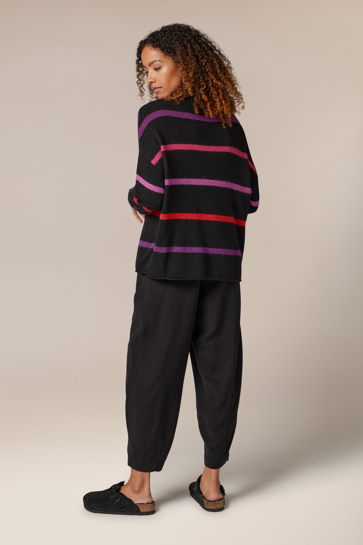 The back view of a woman wearing a Mohair Blend Stripe Sweater.