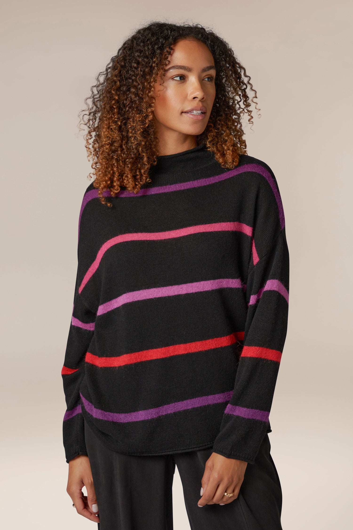 A woman stylishly donning a Mohair Blend Stripe Sweater, showcasing her love for knitwear.