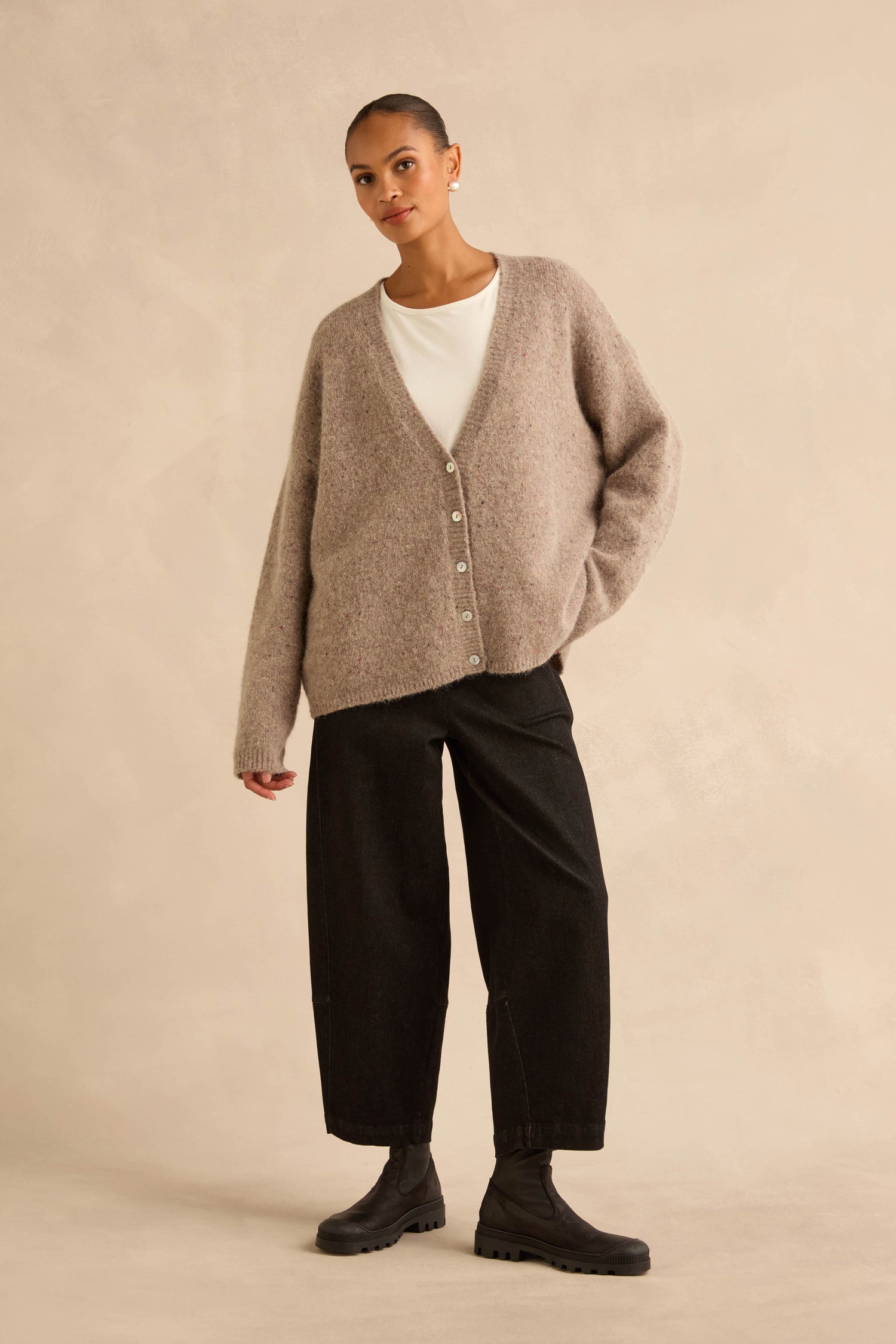 A person wears a Taupe Alpaca Blend Cropped Cardi over a white top, dark wide-leg trousers, and black ankle boots.